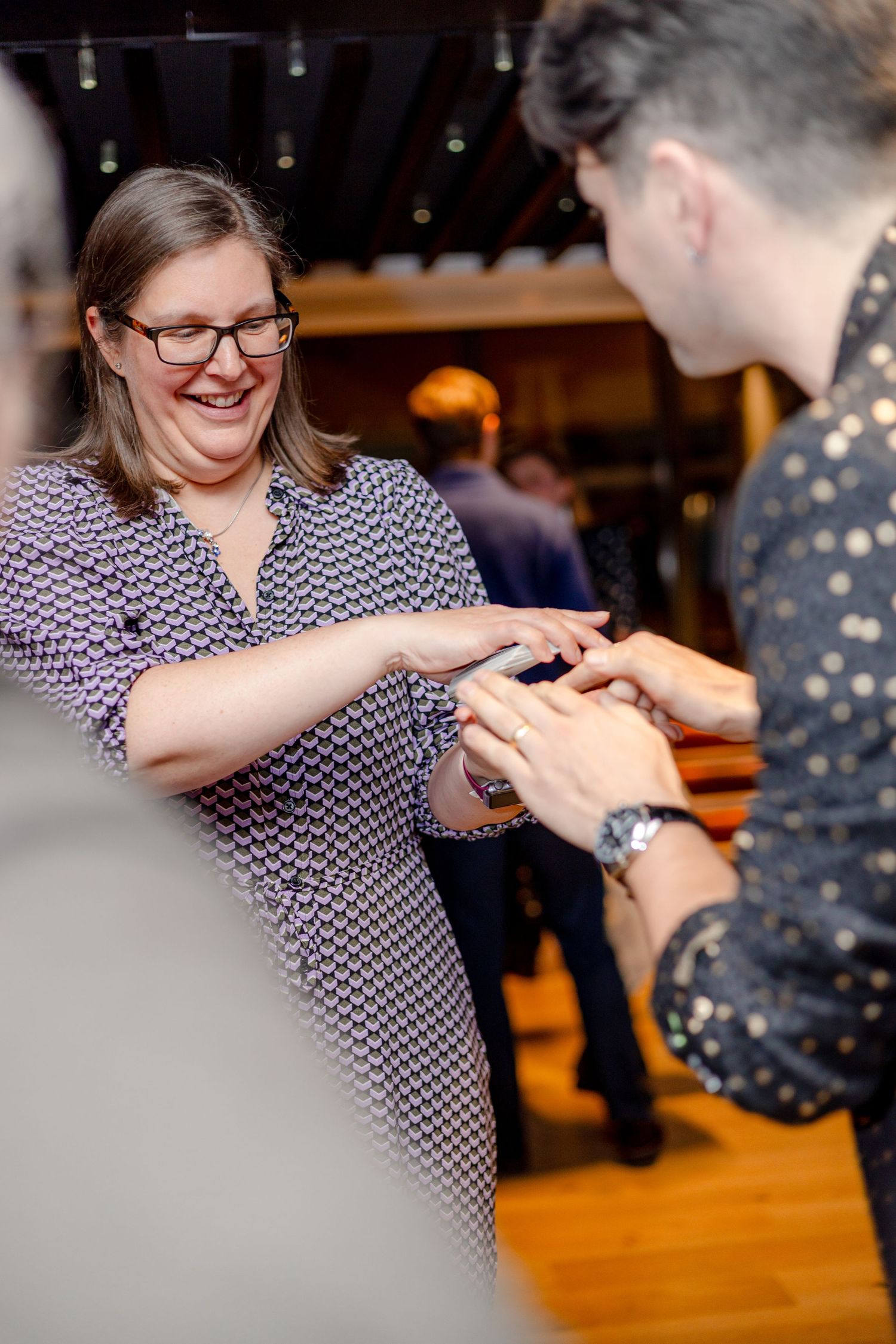 Two people dancing together on a wooden floor at an indoor event.