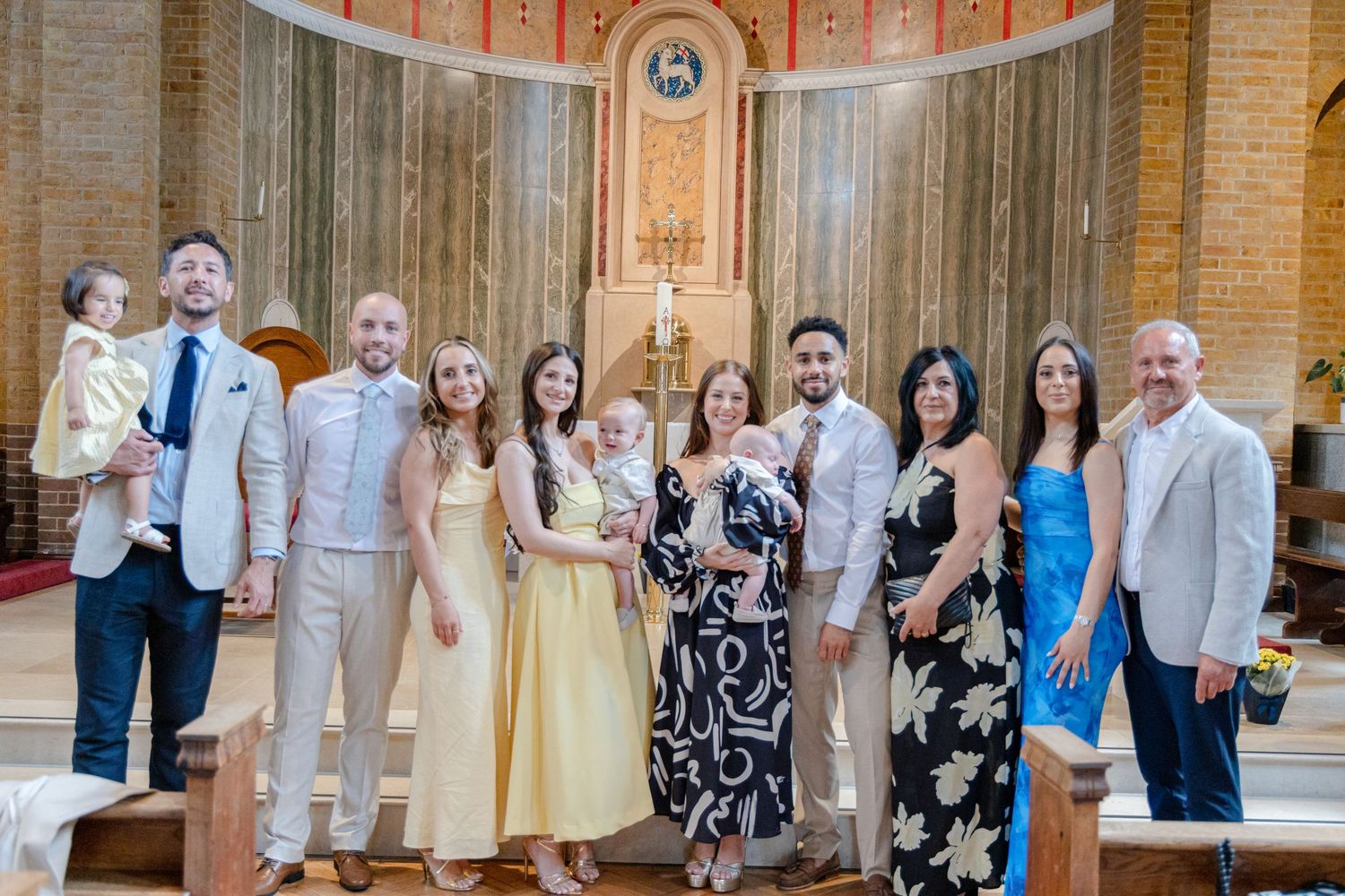 Large group photo of wedding attendees inside a circular brick church.