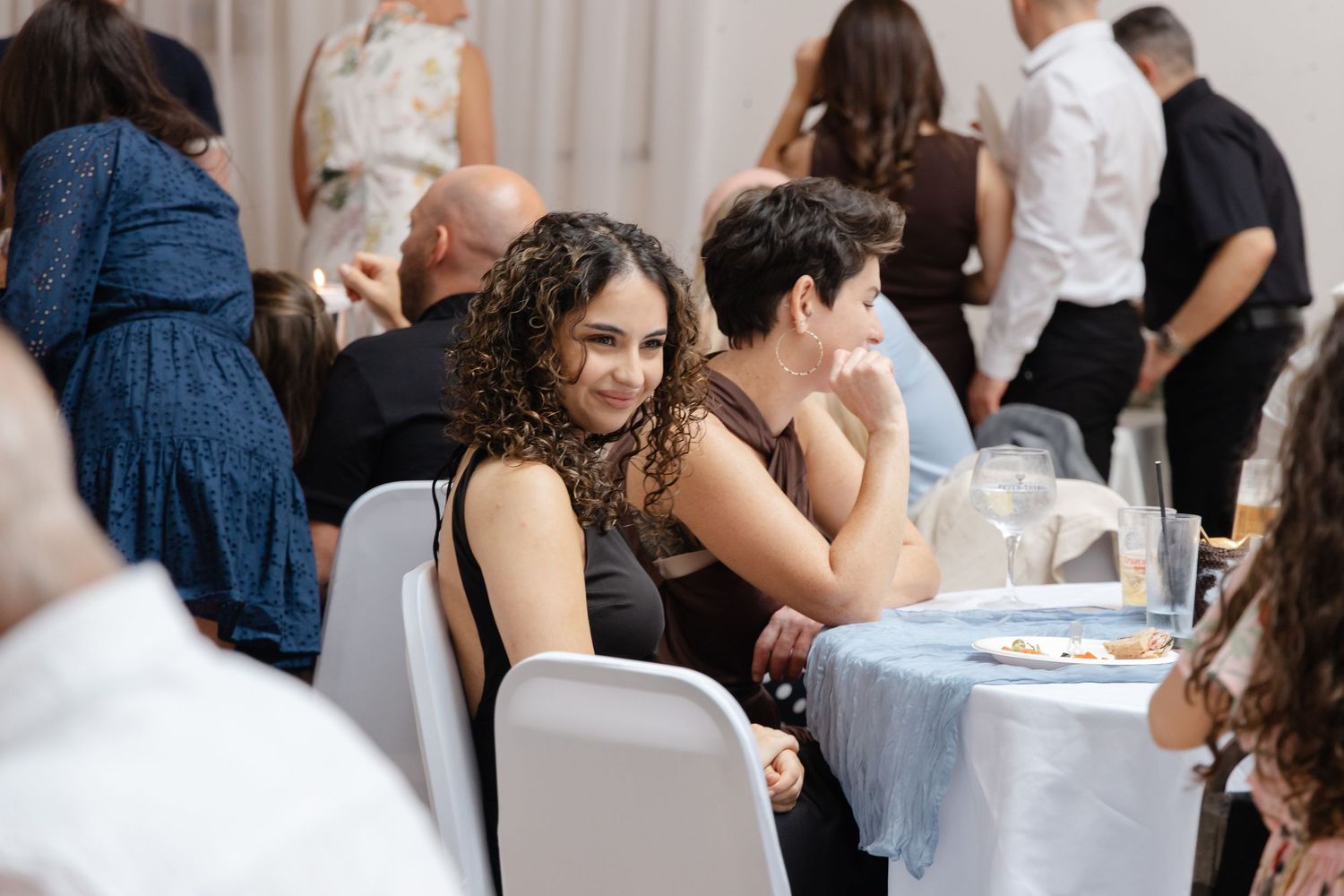 Guests mingling and socializing at an indoor event with white decor.