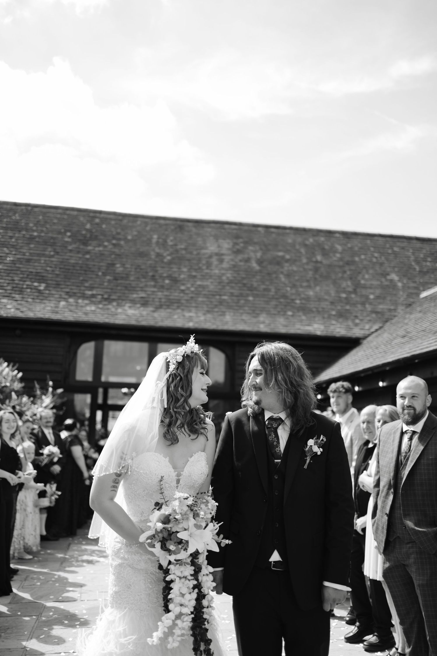 Rustic barn wedding venue with dramatic wooden beams and floral chandeliers.
