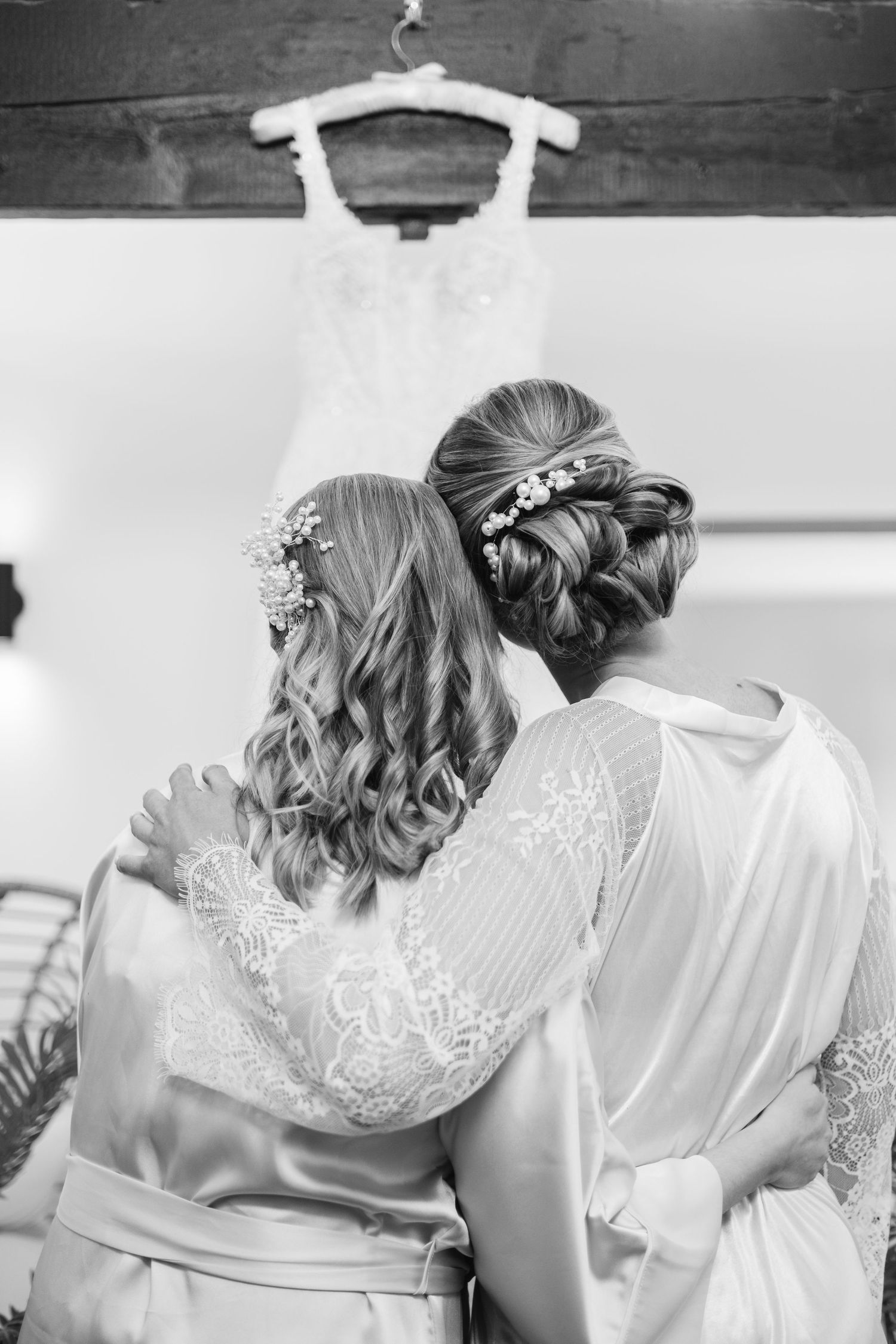 Black and white photo of bridesmaids in matching robes getting ready for wedding day.