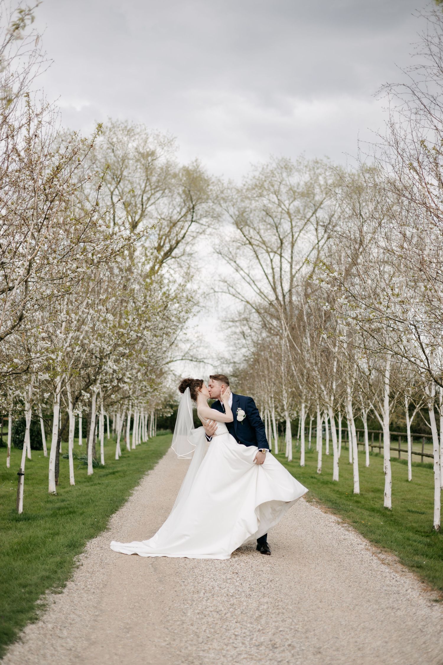 Romantic wedding photo sequence showing couple's intimate moments along tree-lined gravel pathway.