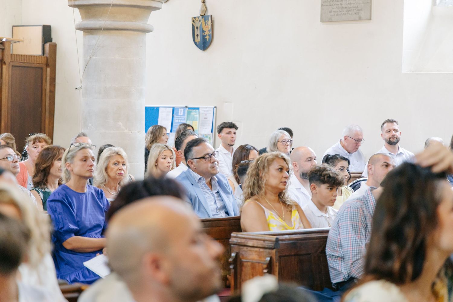Congregation gathered in church pews during a religious ceremony.