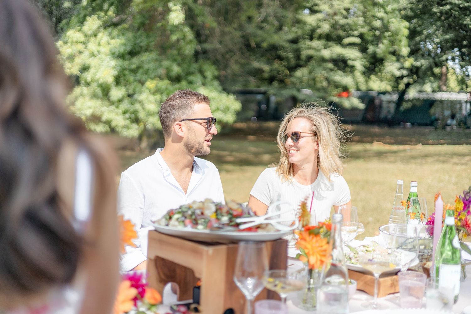 Outdoor garden party table setting with colorful decorations and drinks.