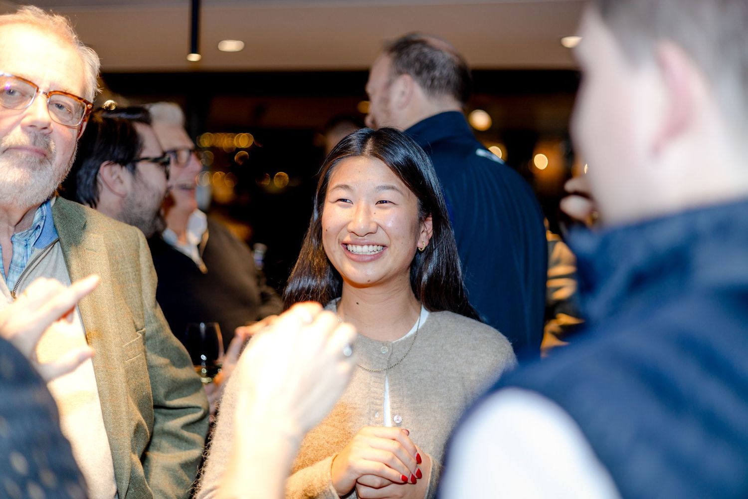 Group of people sharing a lighthearted moment at an indoor social gathering.