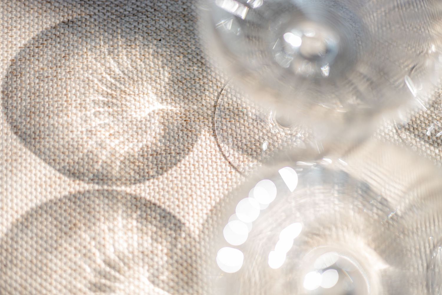 Abstract close-up of glass wine goblets creating a bokeh pattern.
