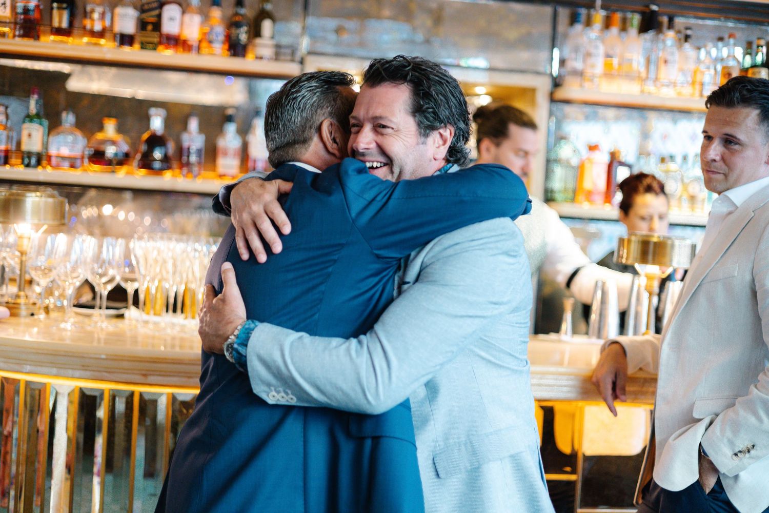Emotional embraces shared between guests at an indoor celebration.