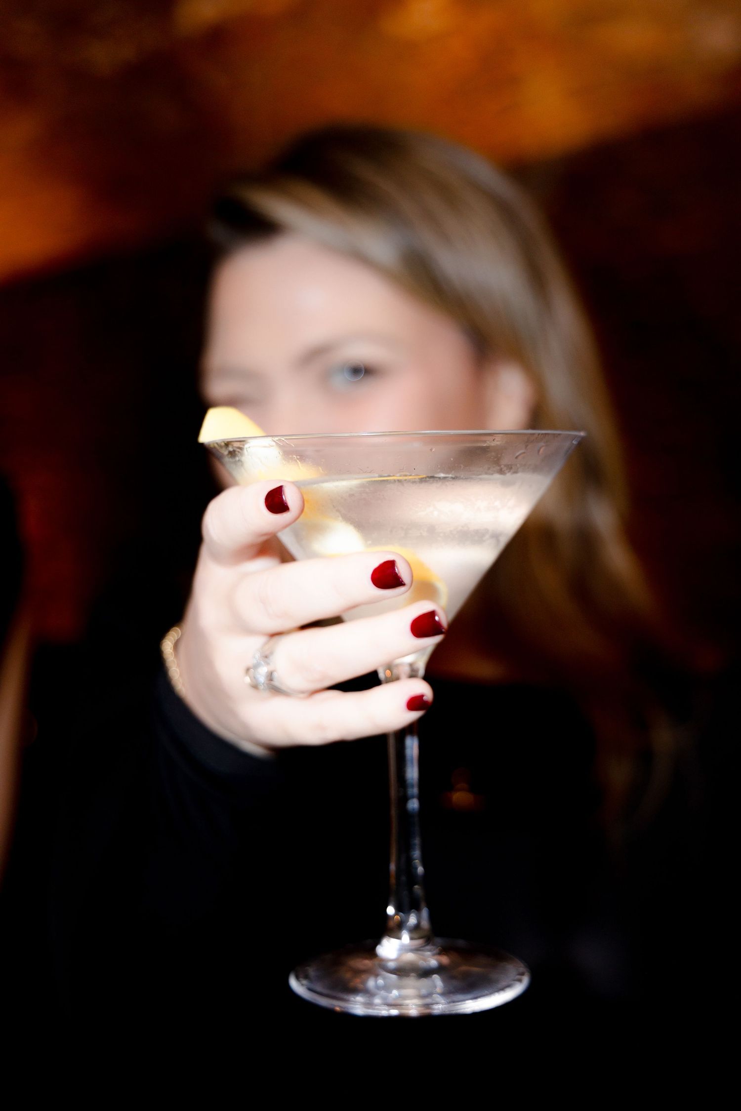 Elegant martini glasses with garnishes being served at an upscale event.