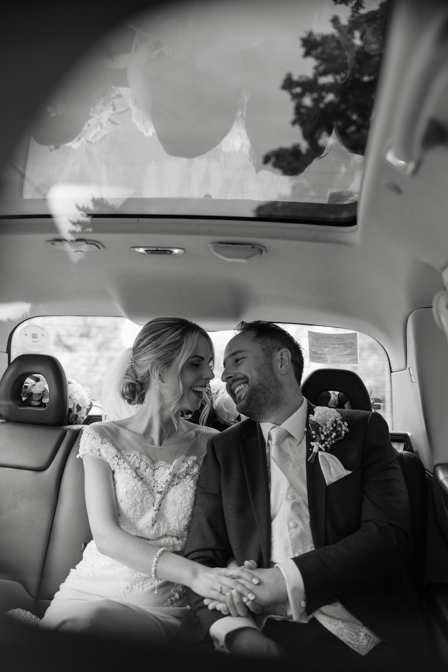 Black and white photos of newlyweds sharing intimate moments in wedding car.