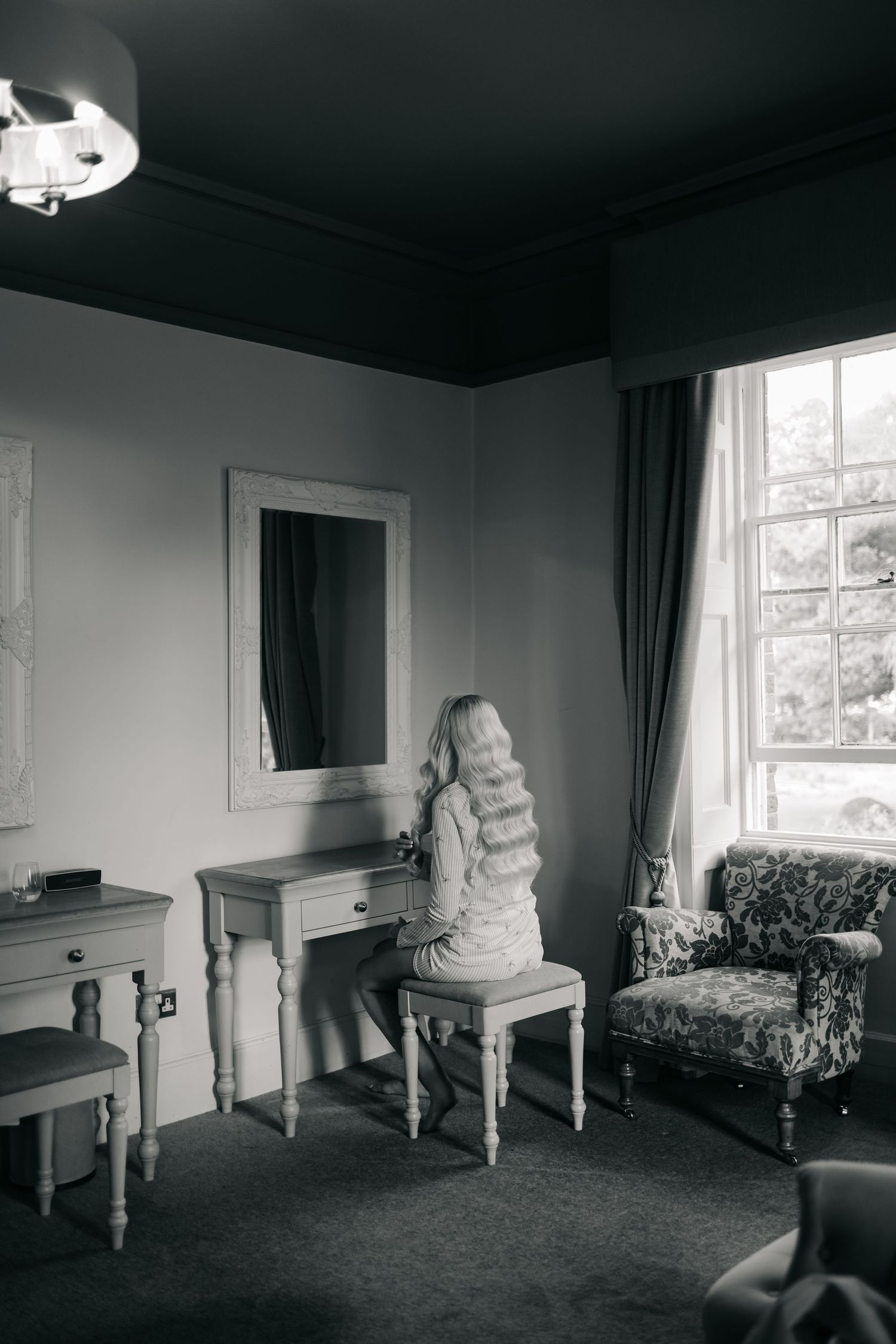 Classic black and white photo of an elegant bridal preparation room with vintage furniture.