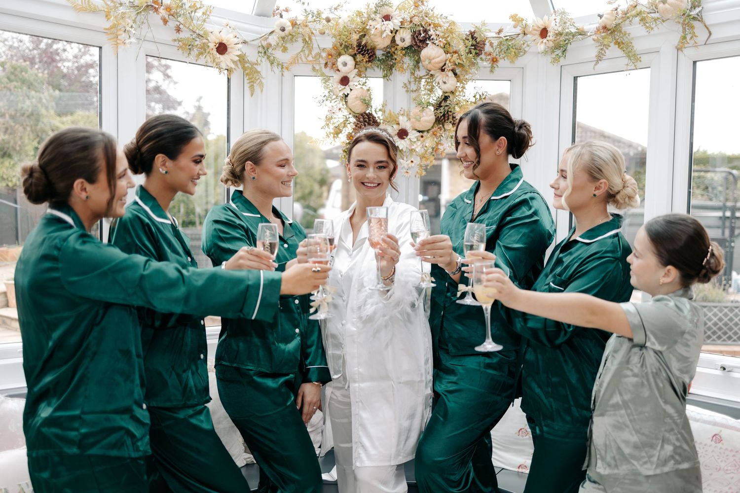Healthcare workers in green scrubs celebrate together in bright indoor setting.
