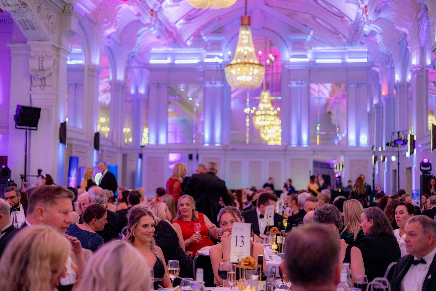 Elegant ballroom venue illuminated in purple light during an evening celebration.