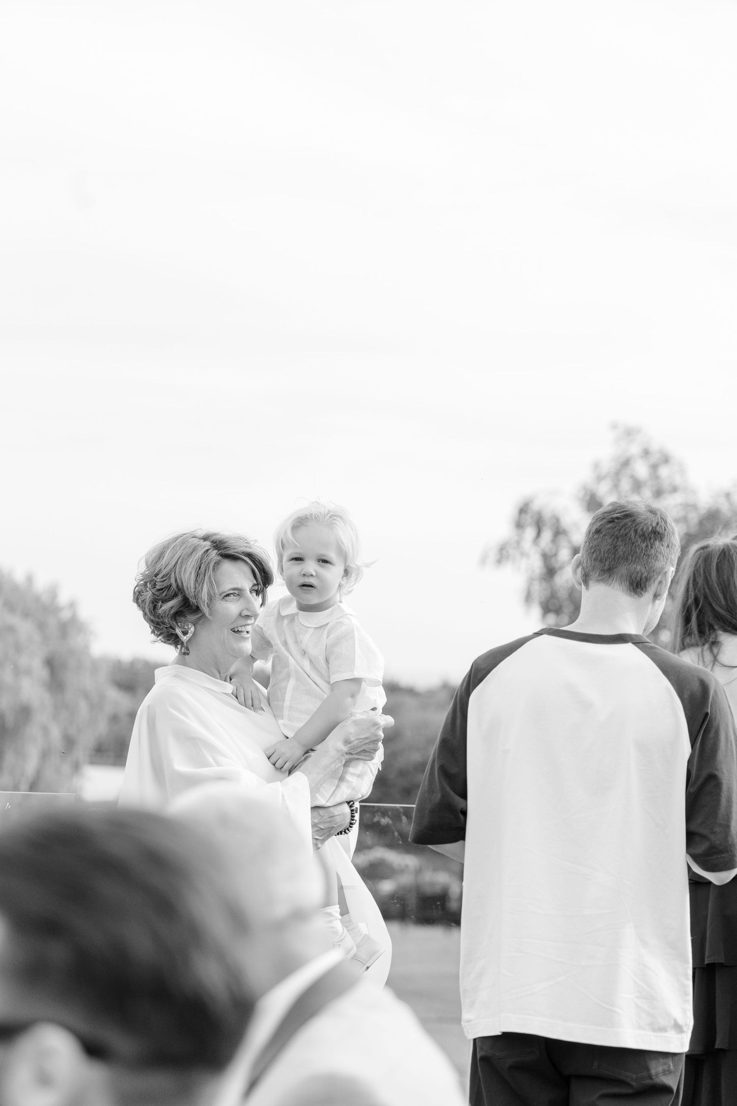 A joyful outdoor gathering with people enjoying refreshments in black and white photography.