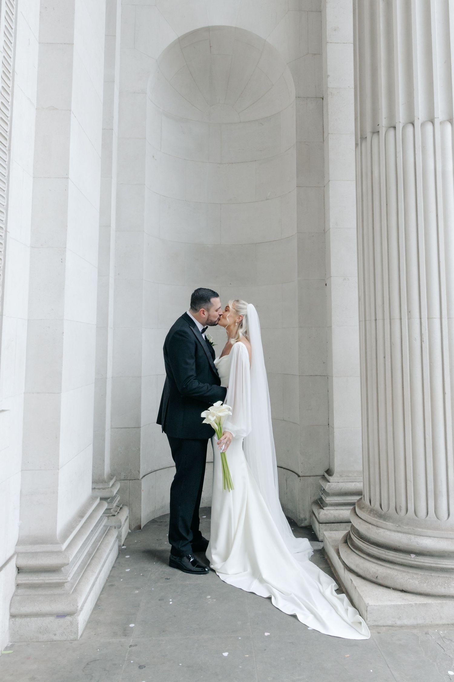 Romantic wedding portraits between classic white stone columns.