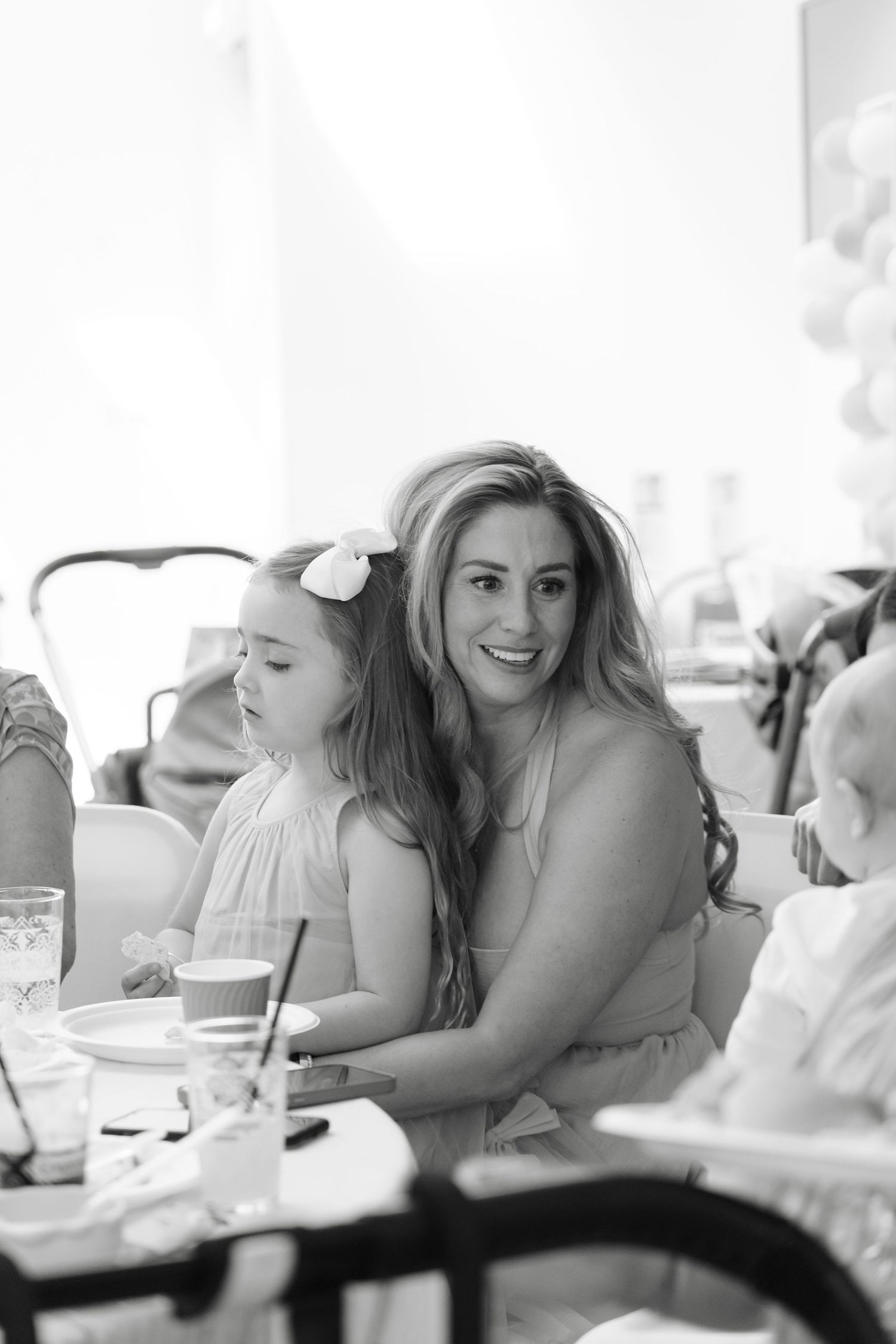 A candid black and white photo of two guests enjoying themselves at a celebratory event.