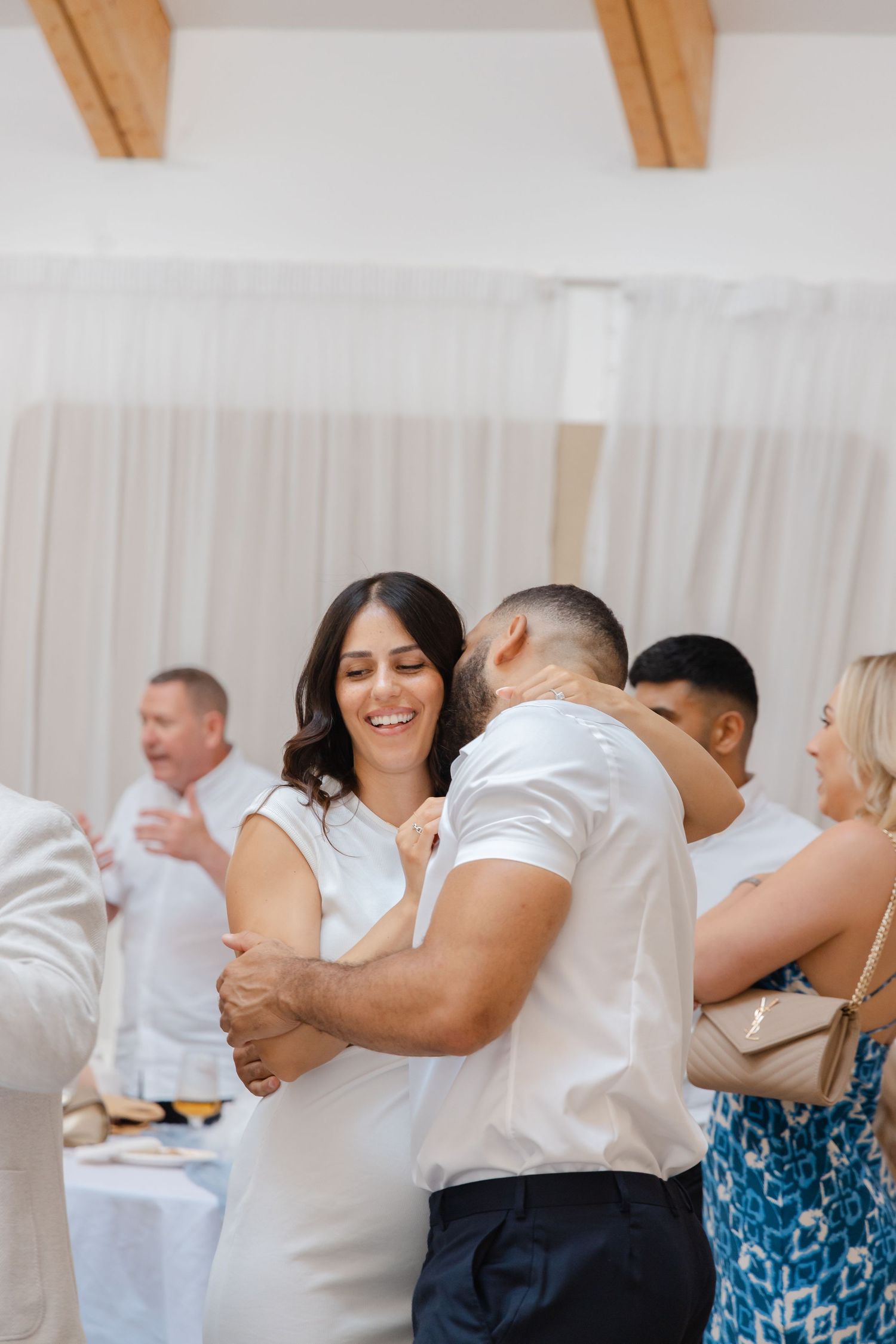 A couple sharing a joyful embrace while dancing at a celebration.