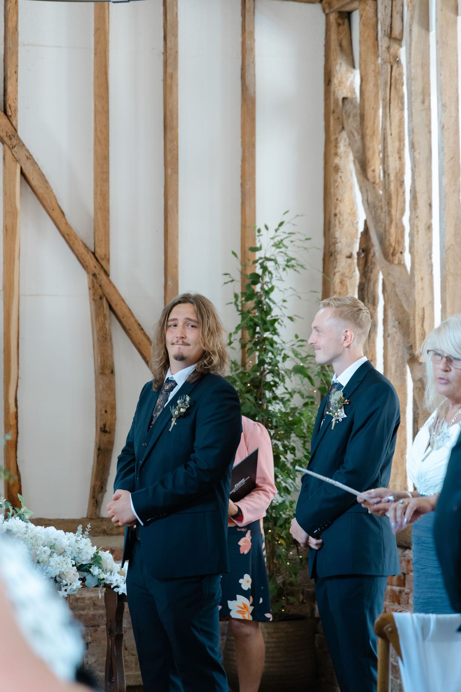 Black and white photo of a wedding ceremony in a rustic barn setting.