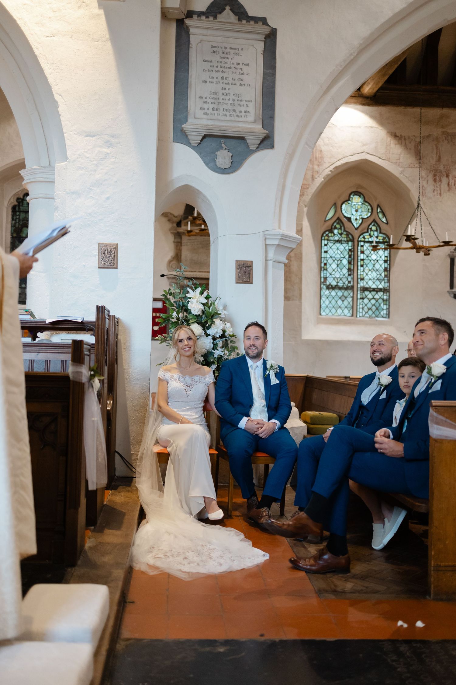 Wedding ceremony taking place inside a historic stone church with arched windows and traditional architecture.
