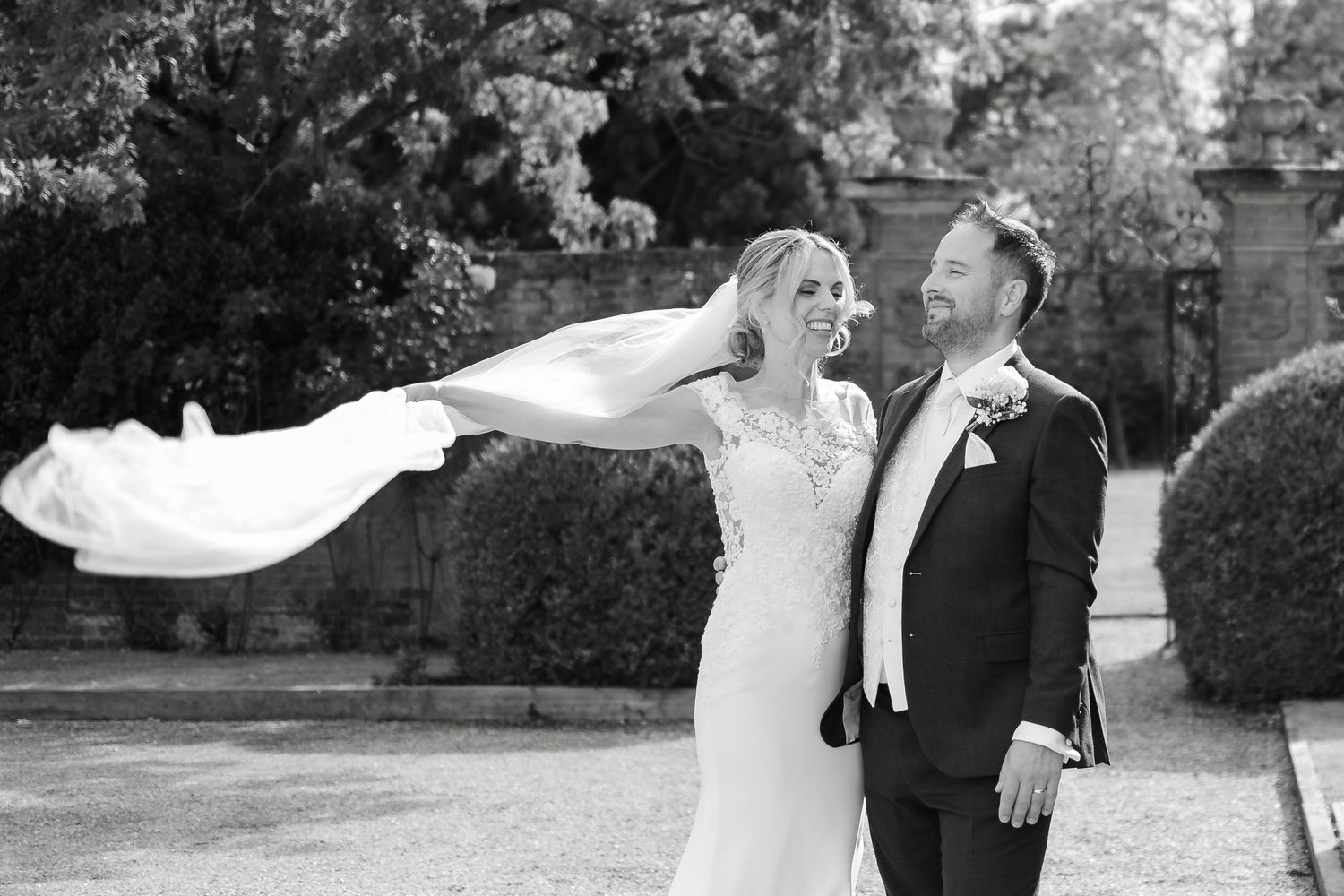 Wedding couple sharing intimate moments in a garden setting with dramatic lighting.