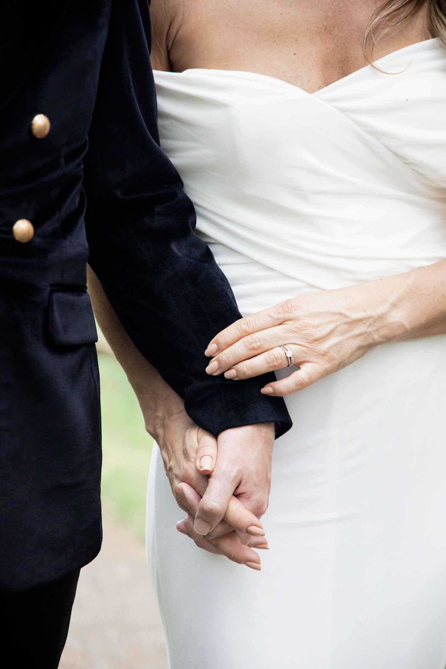 Close-up details of wedding couple's hands and dress during intimate moments.