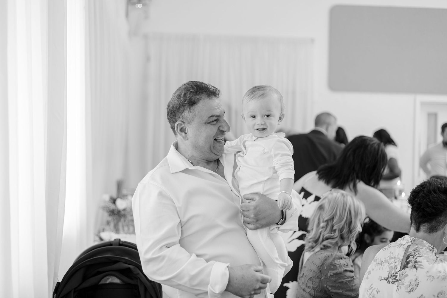 Black and white photo of guests mingling at church event.