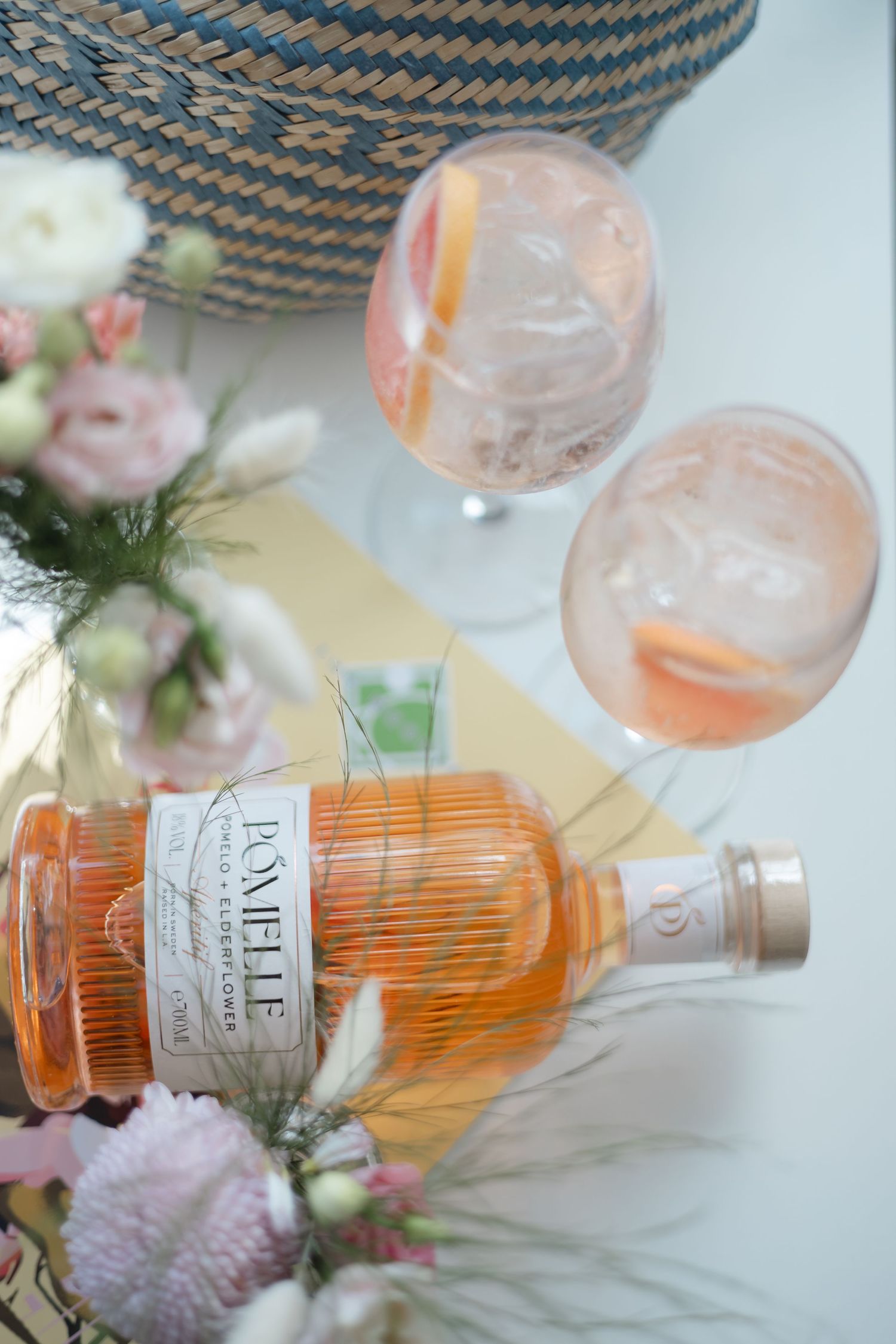 Bottles of rosé wine displayed with delicate pink flowers and decorative glassware.