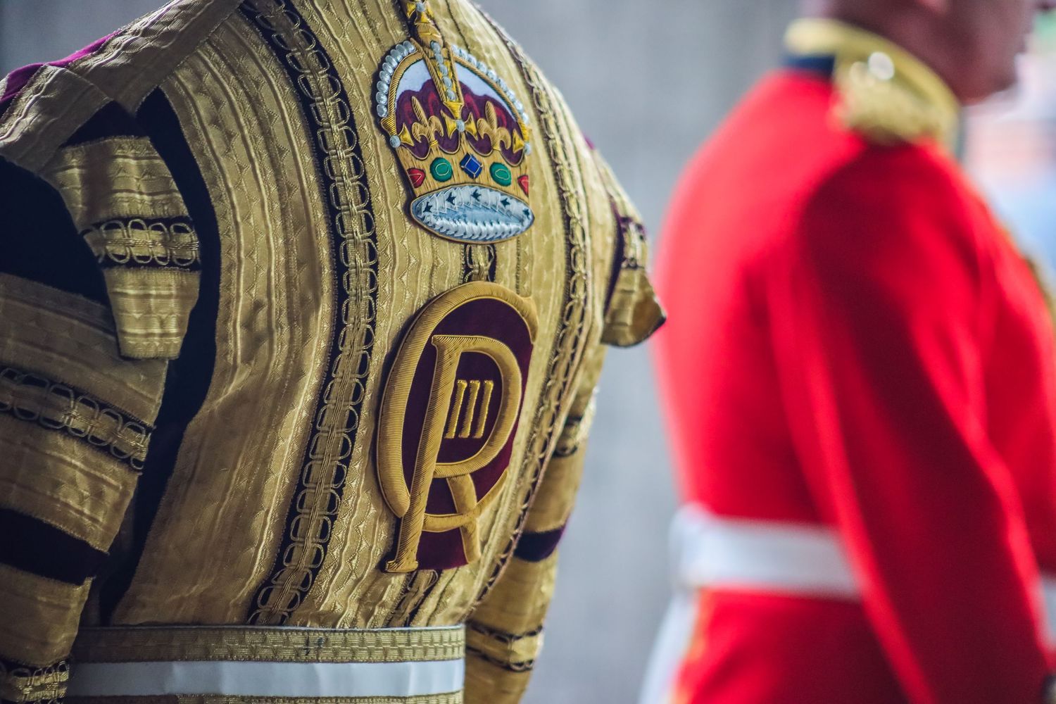 Detailed view of military cap with ornate gold embroidery and royal insignia.