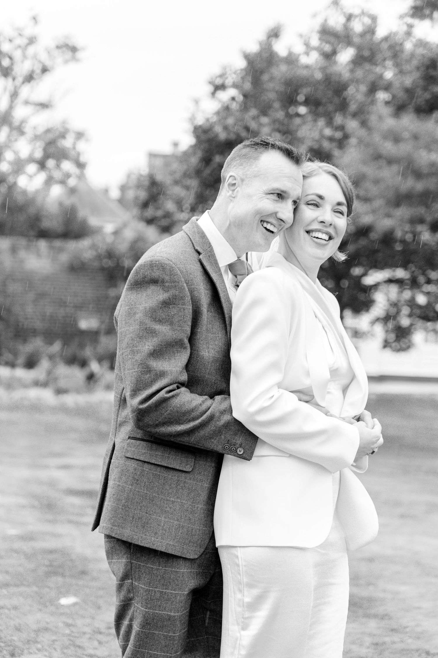 Candid black and white photos of a couple laughing together outdoors.