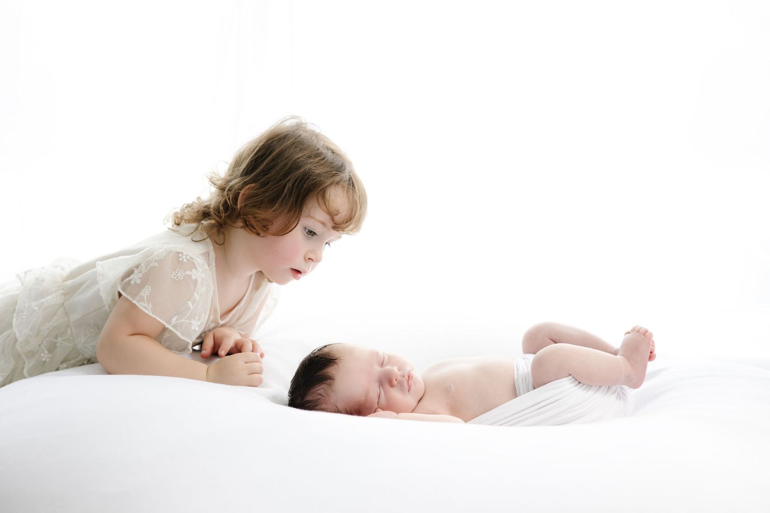 Gentle moments between mother and sleeping baby on white background.