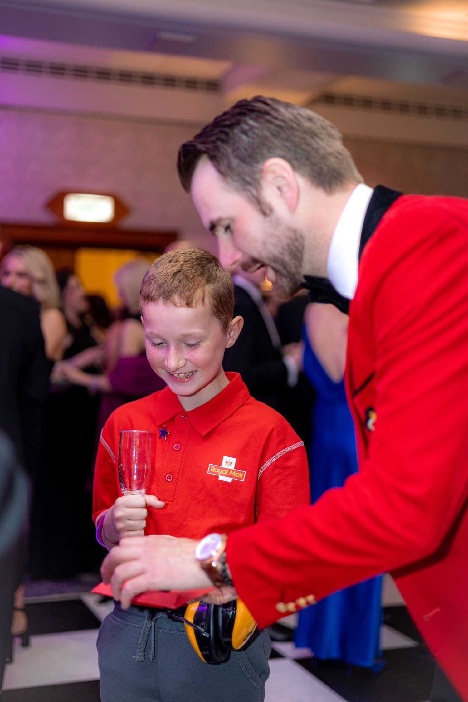 Interactive moment at celebration event with bright red attire visible.
