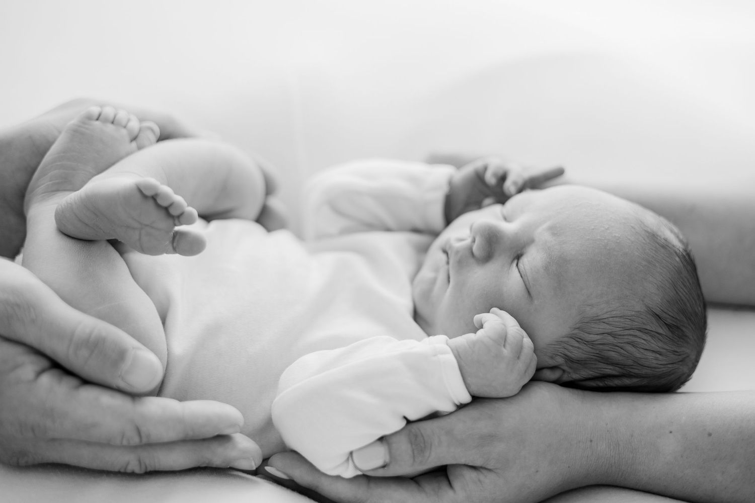 Minimalist black and white newborn photography series on white background.