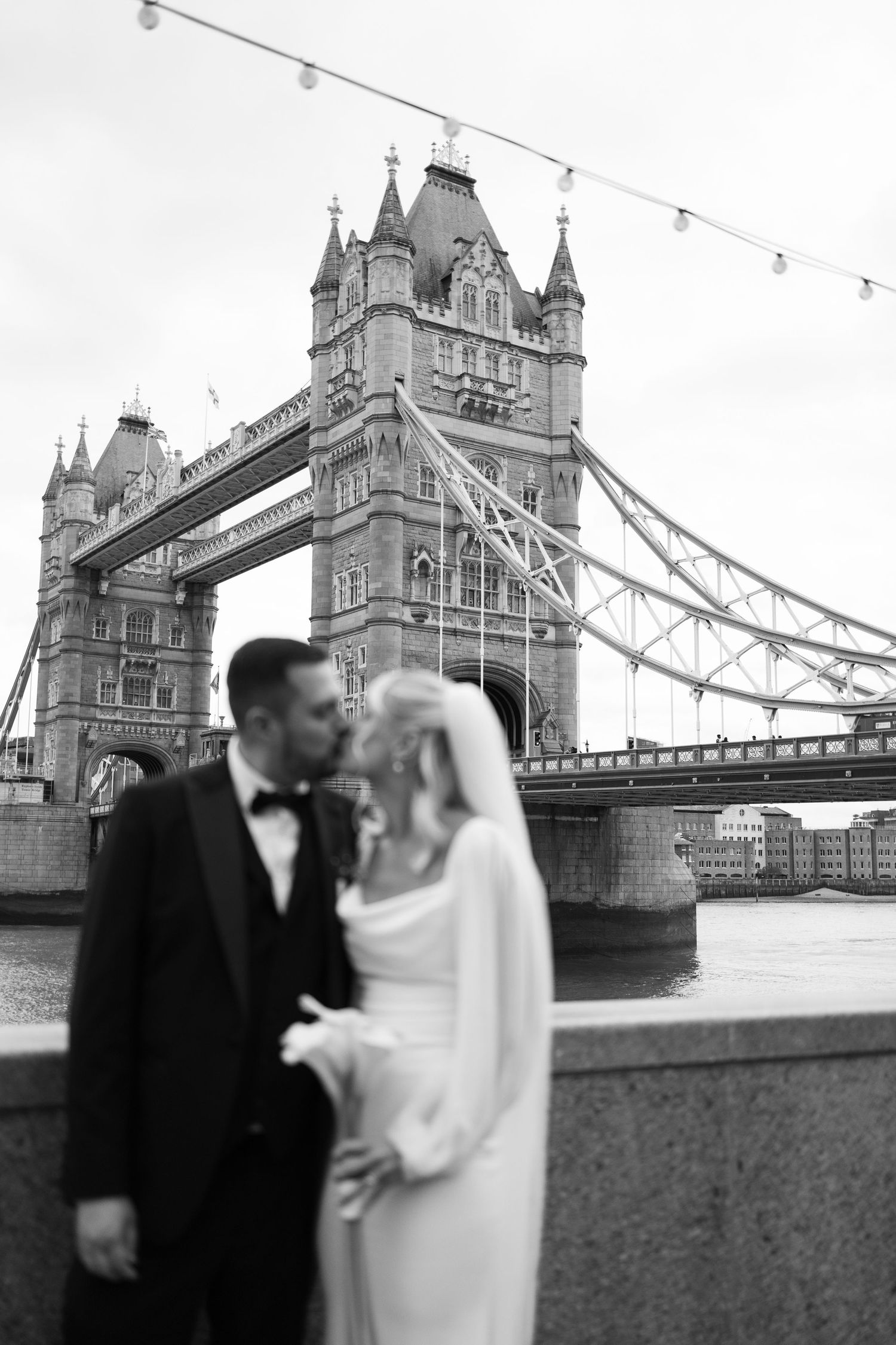 Black and white wedding portraits captured with London's Tower Bridge as backdrop.