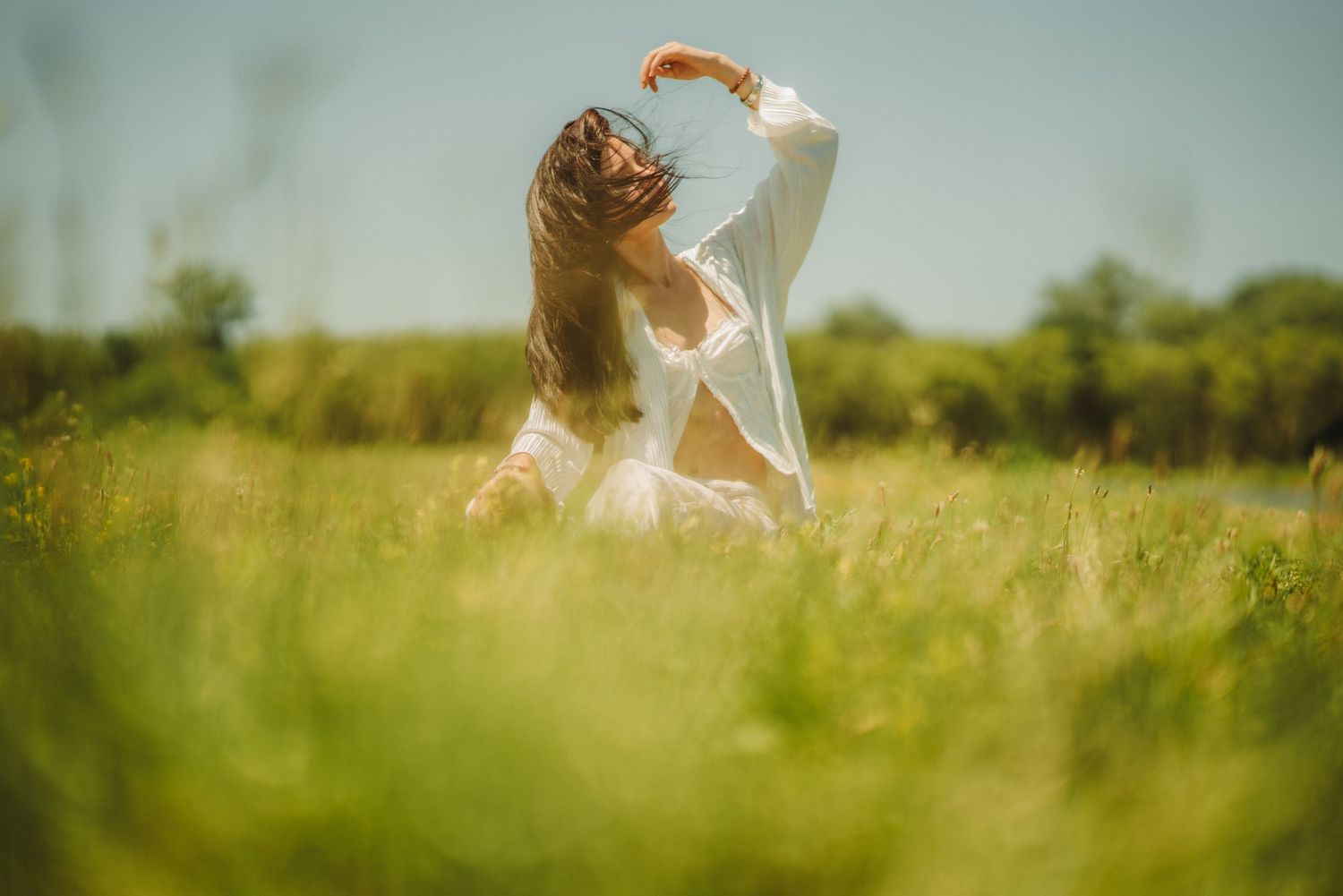 Ethereal photography sequence captured in a sunlit meadow with flowing fabric.