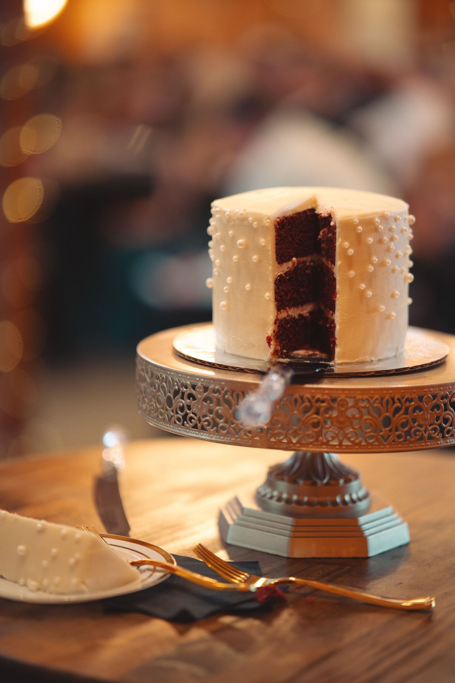 White wedding cake with chocolate interior sits on display at reception.