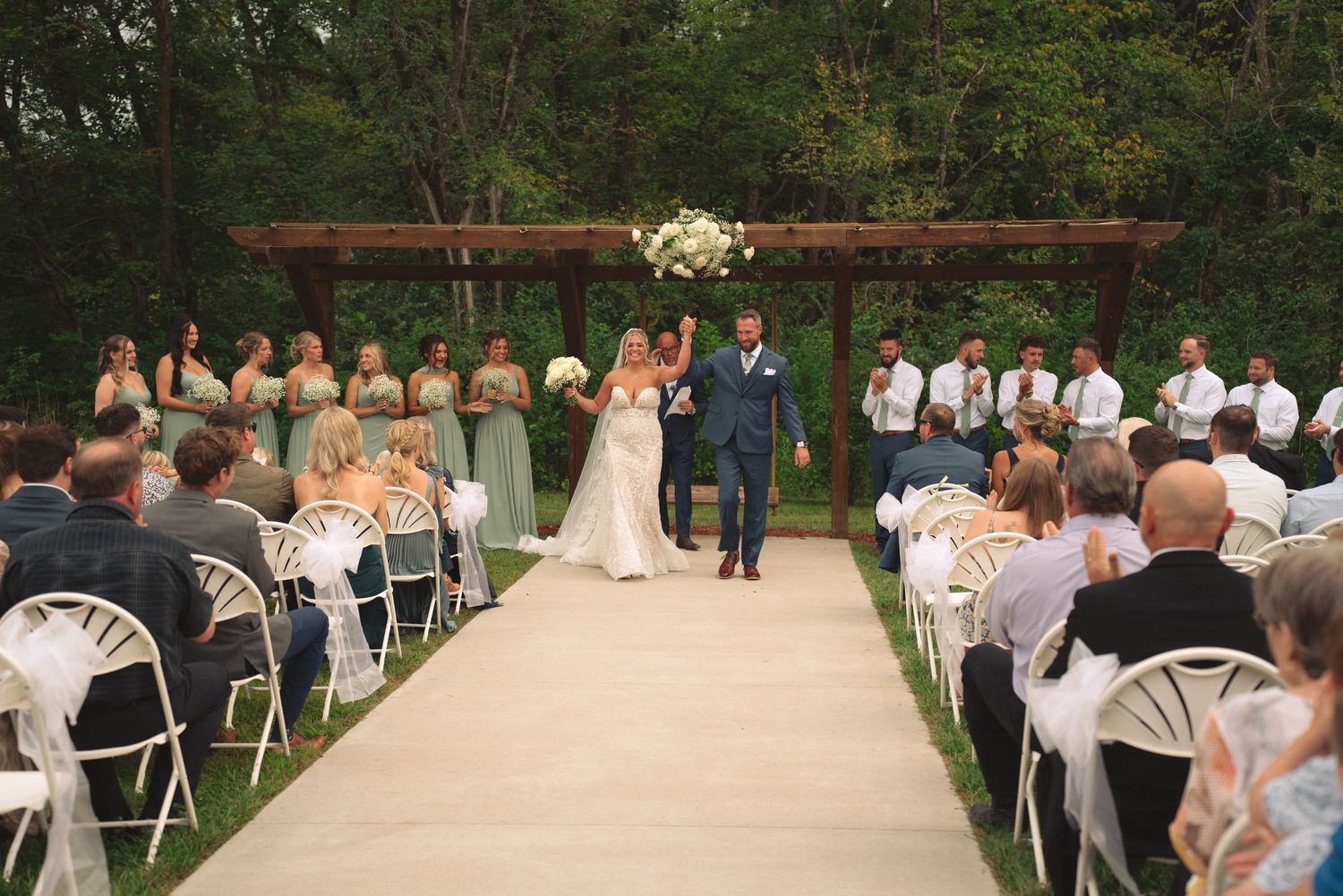 Rows of white chairs arranged on a lawn for an outdoor wedding ceremony.