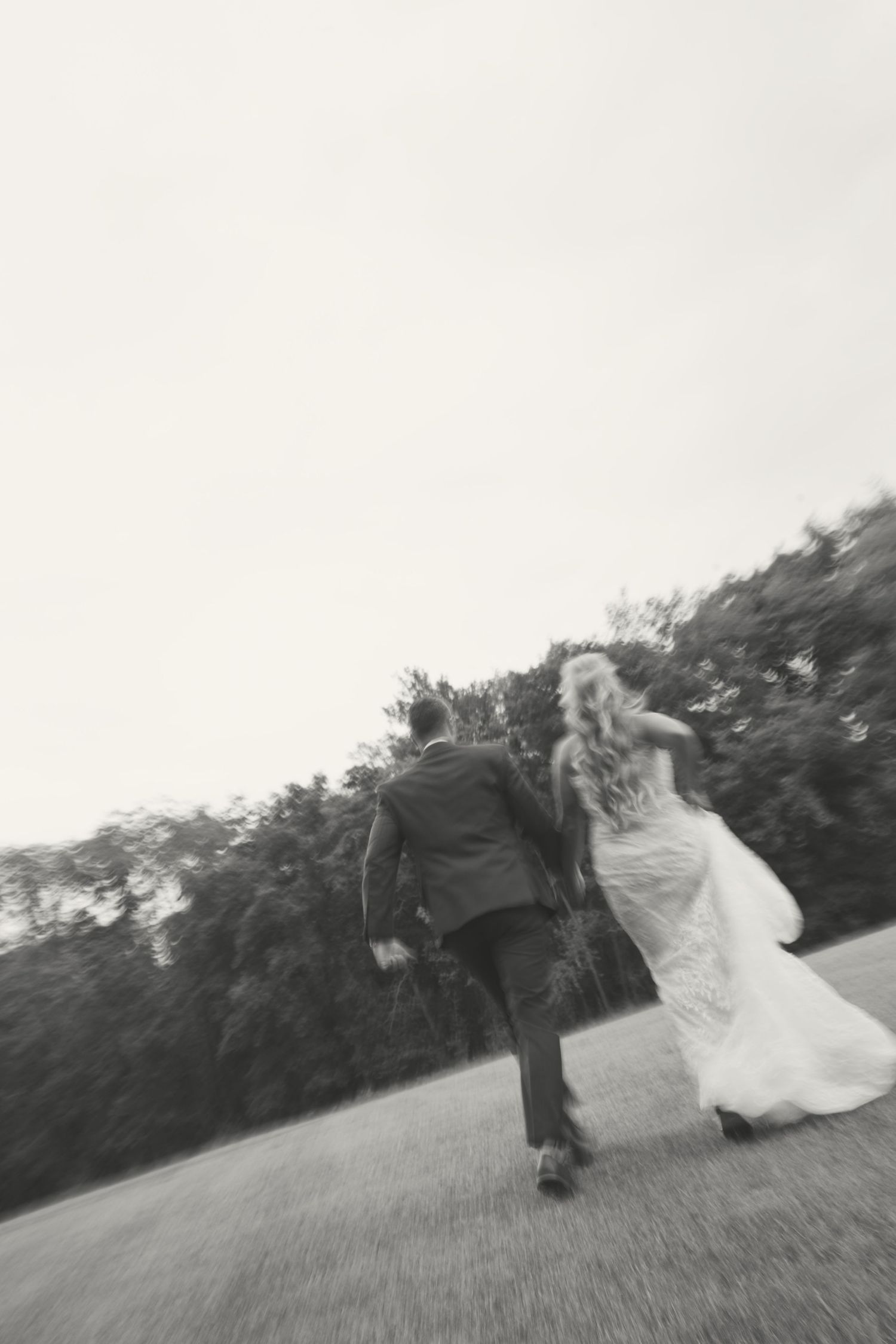 Artistic black and white sequence of newlyweds walking in a field.