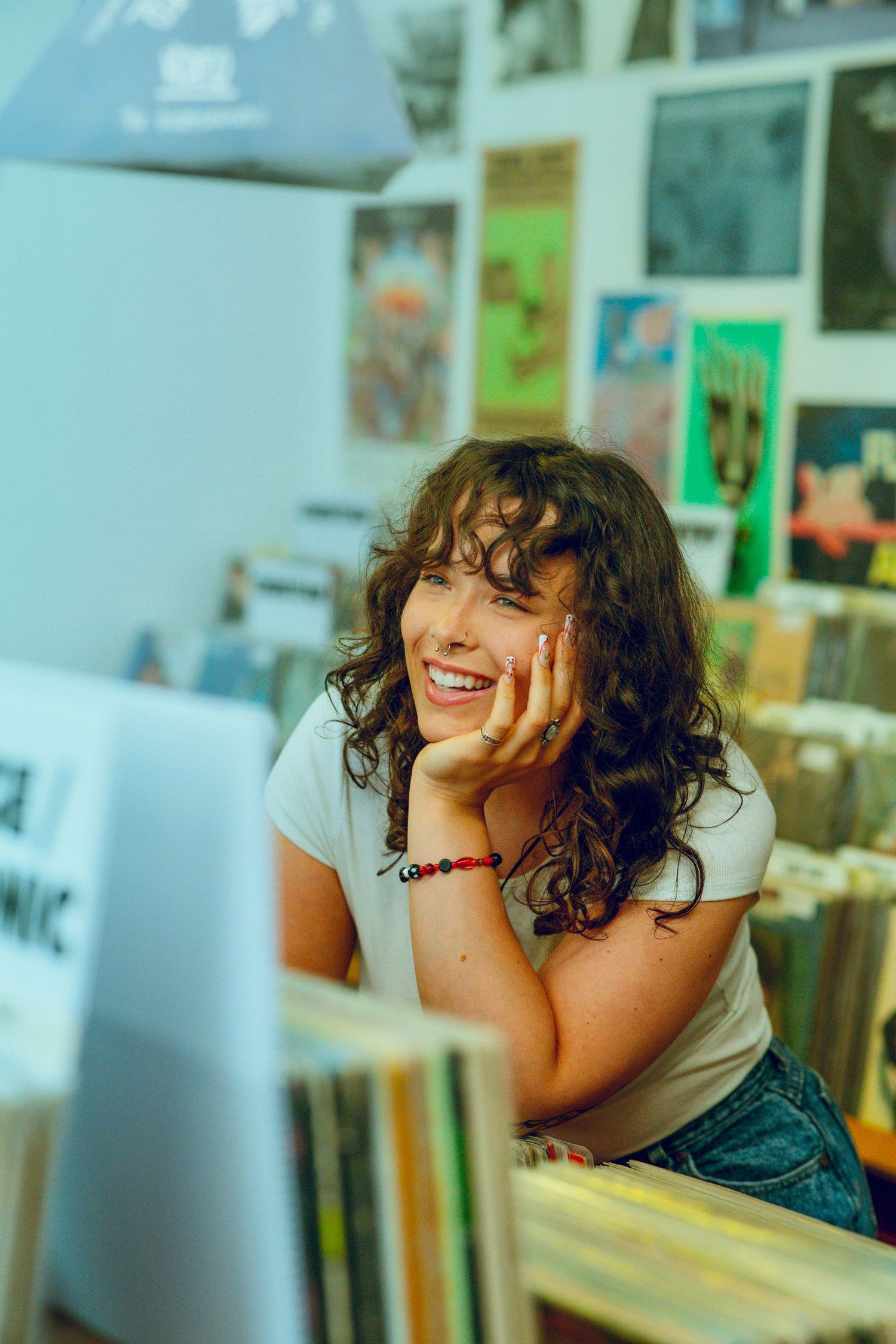 Candid portrait sequence showing joyful laughter and curly hair against a bright background.
