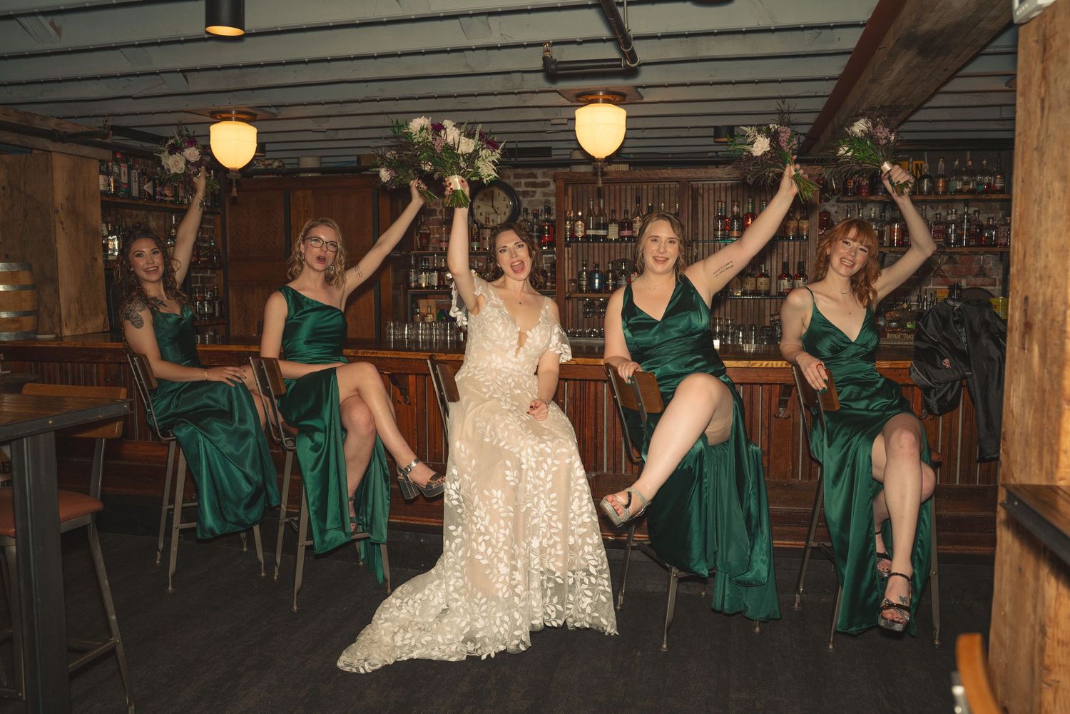 Wedding celebration in rustic venue with wooden beams and hanging lights.
