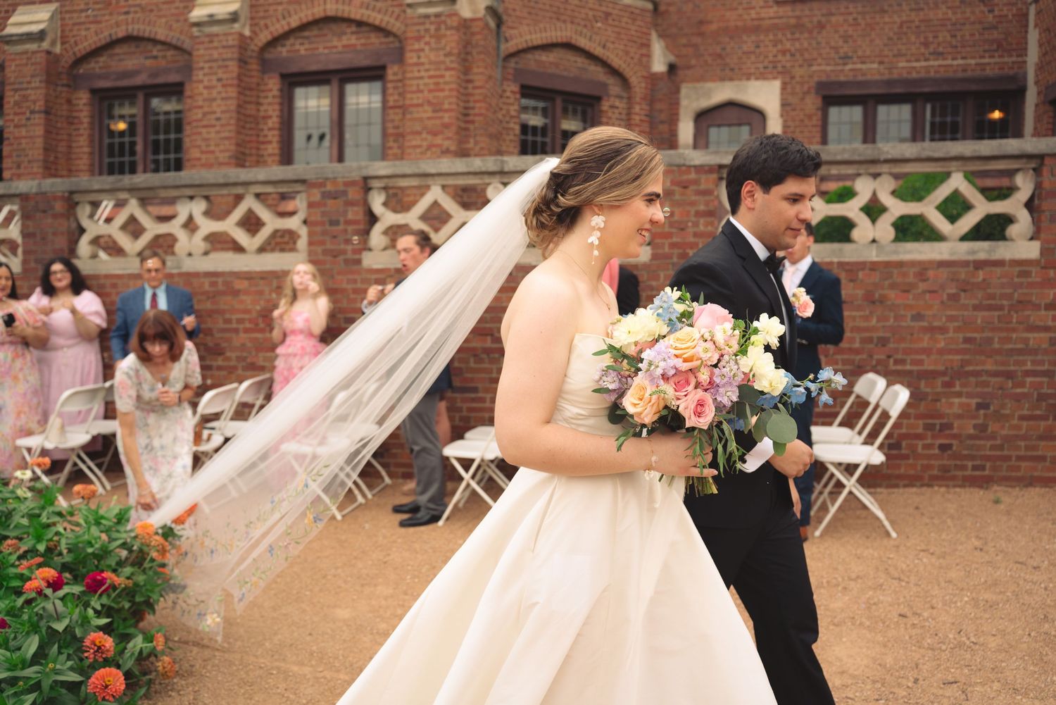 Wedding couple sharing a romantic moment in a garden with blooming flowers.