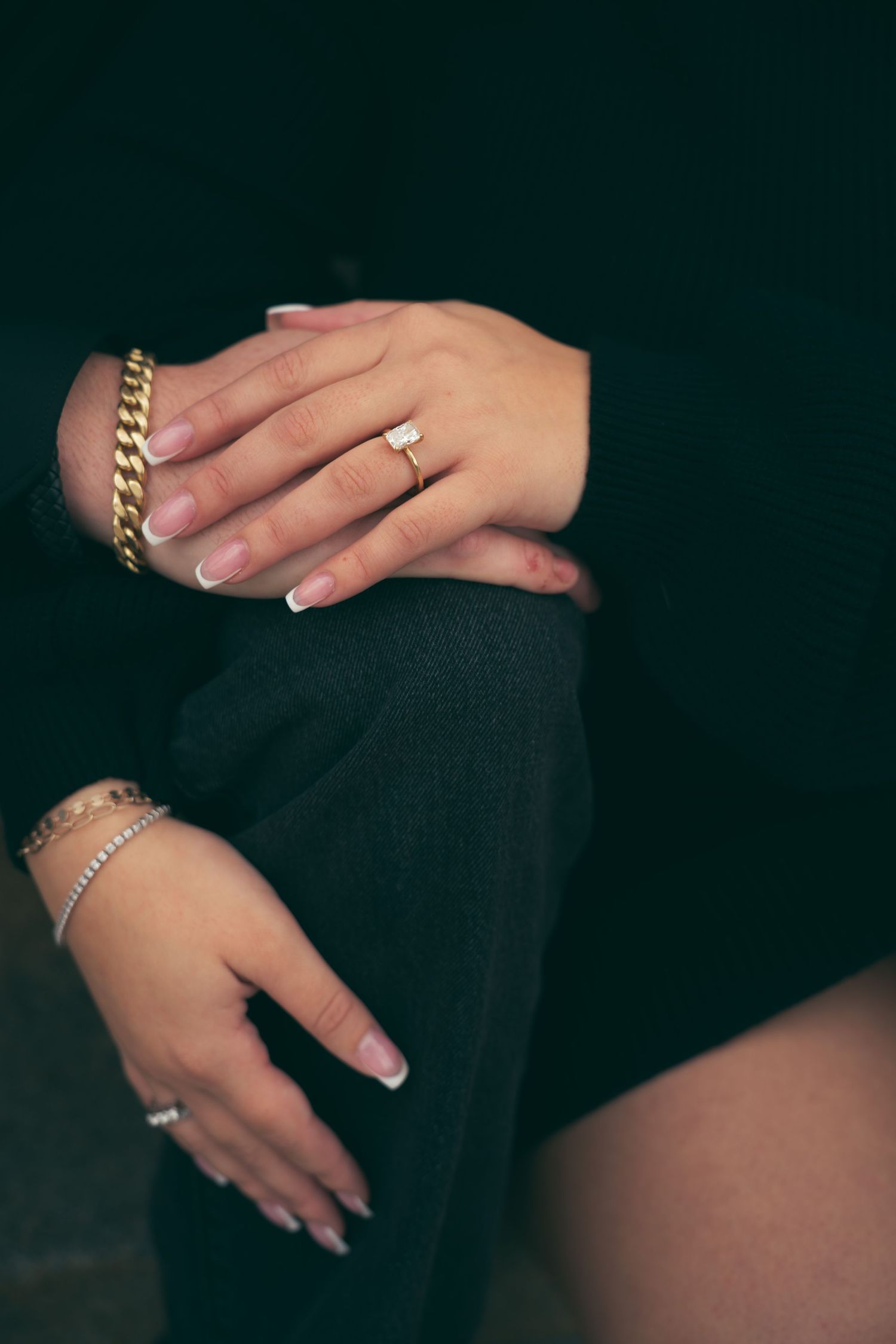 Close-up shots of hands wearing gold chain bracelets, rings and diamond jewelry against a dark background.