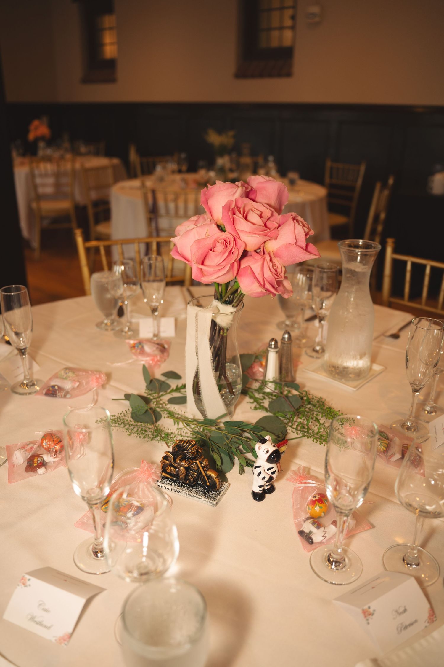 Elegant wedding reception table with pink floral centerpieces and crystal glassware.