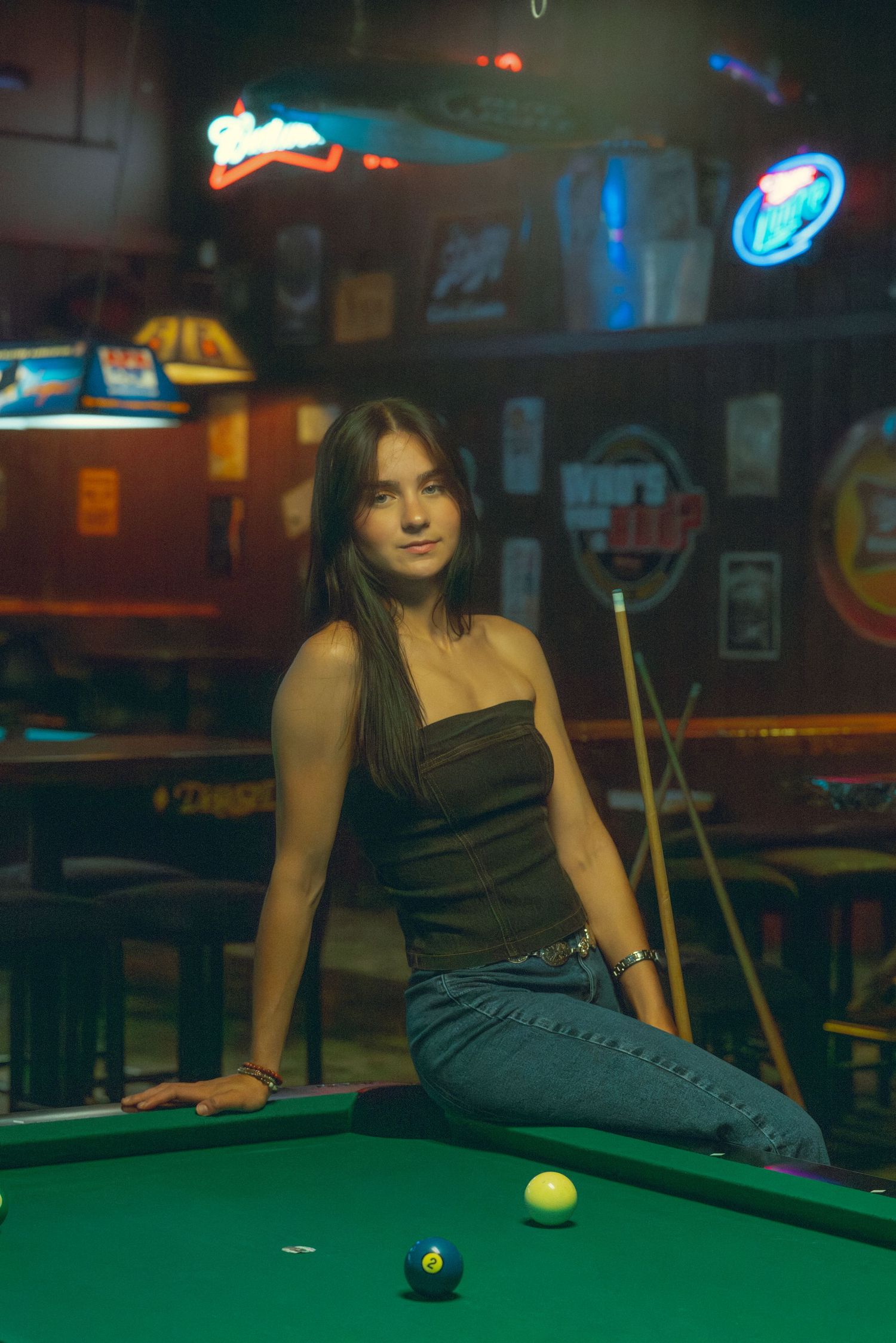 Atmospheric pool hall scene with neon lights and green felt table.