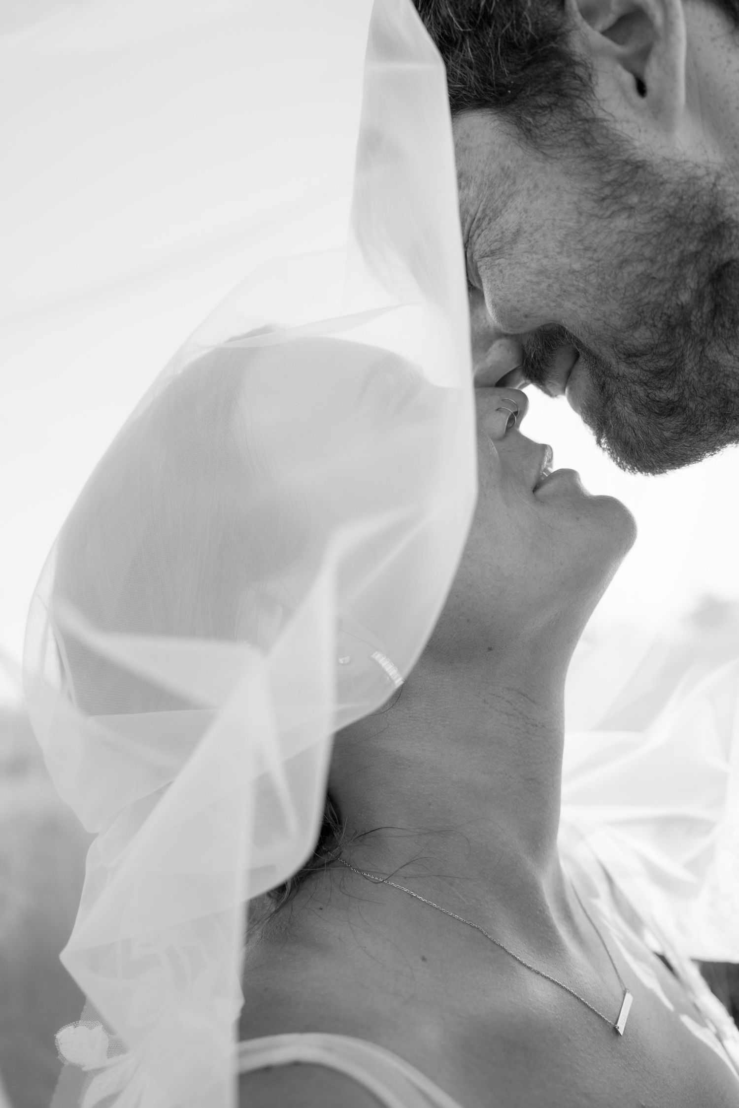 Intimate black and white portrait with soft white fabric veil.
