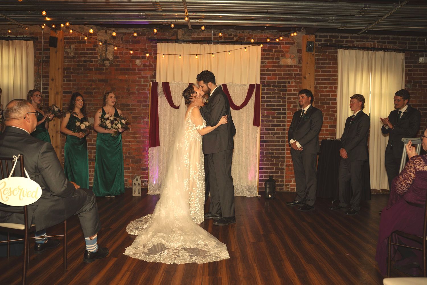 Wedding reception dance floor with guests celebrating in rustic venue.