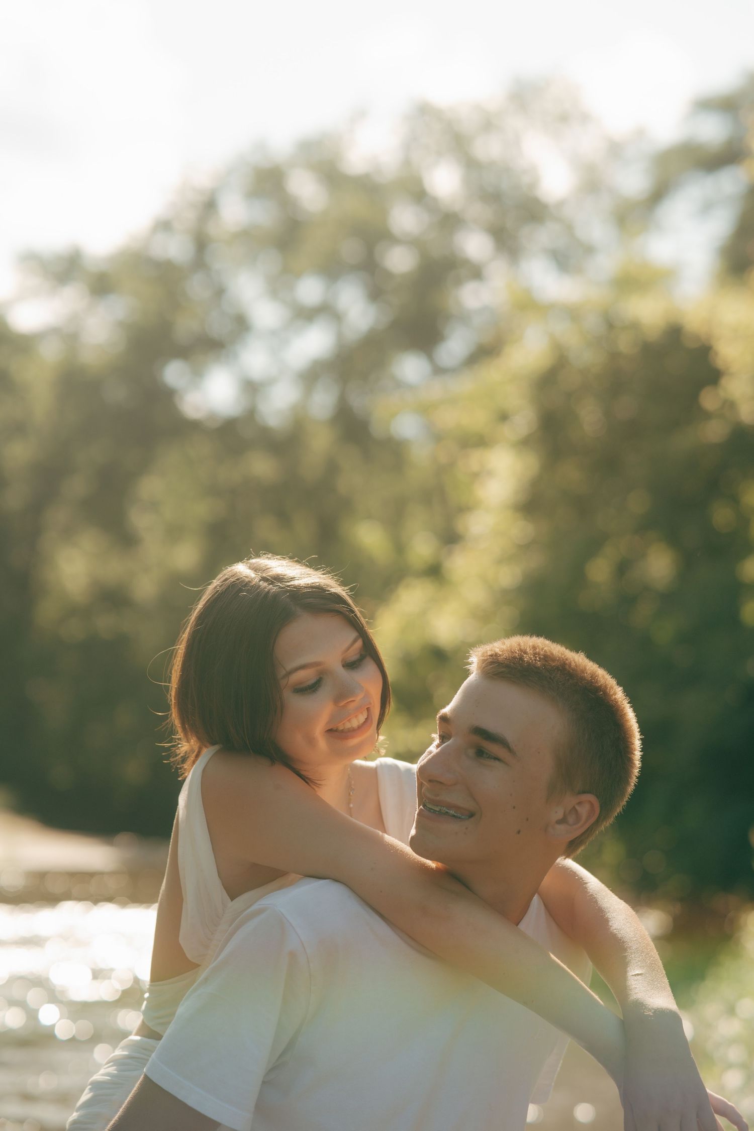 Couple embracing during golden hour photoshoot by the water.
