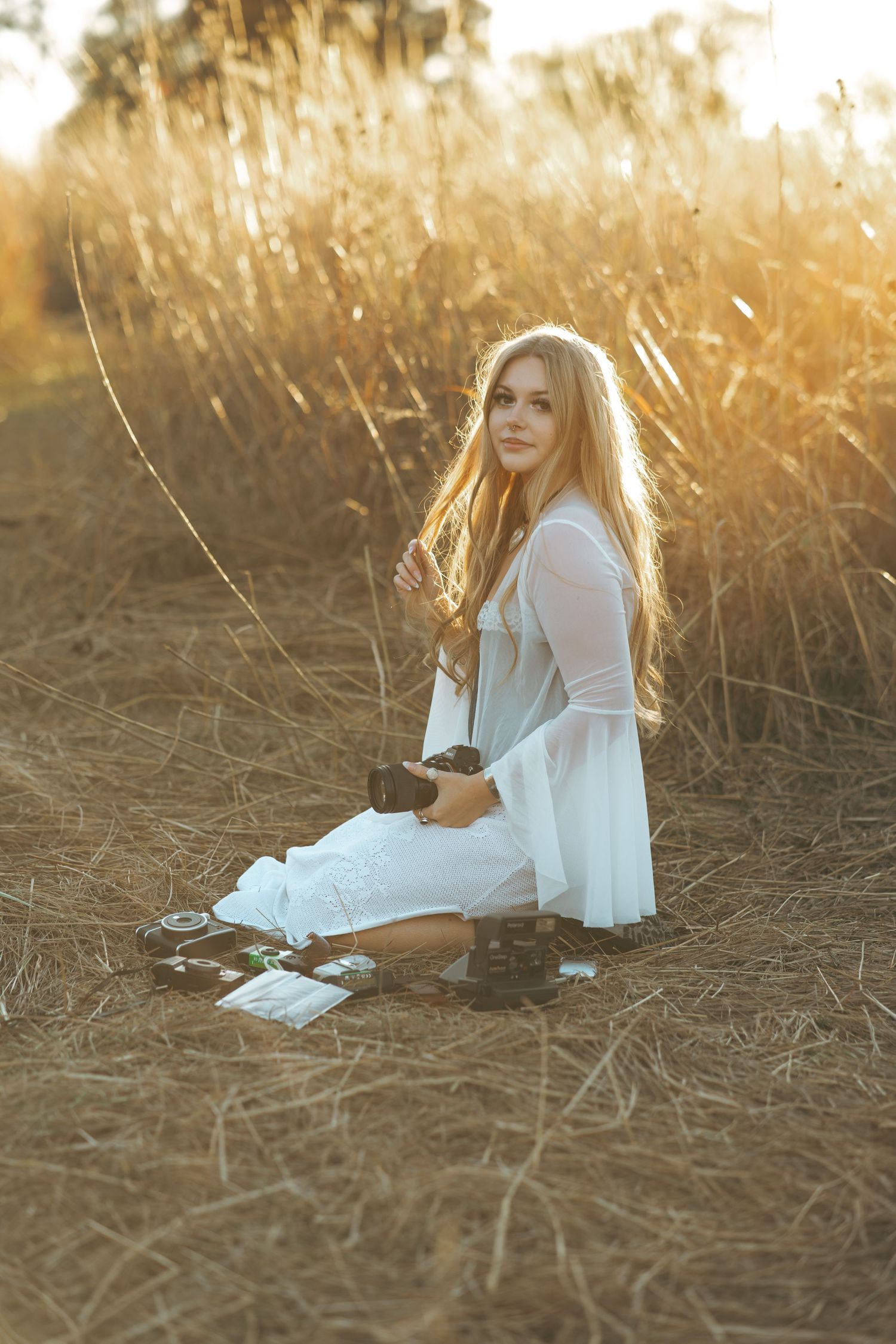 Natural light portrait in a wheat field with soft golden sunlight filtering through.