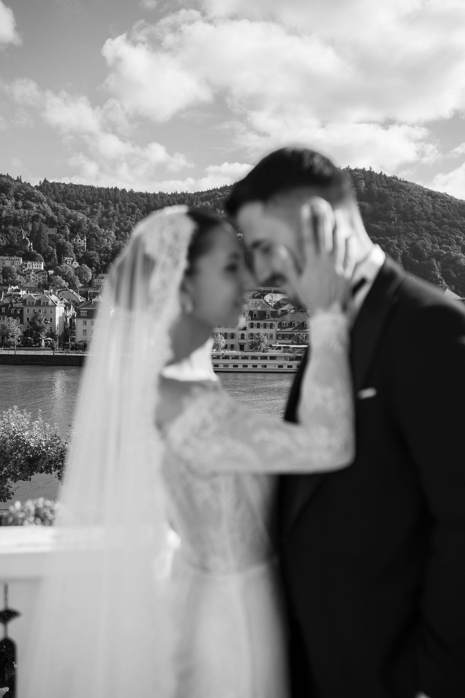 Romantic black and white wedding portraits on a balcony with mountain scenery.