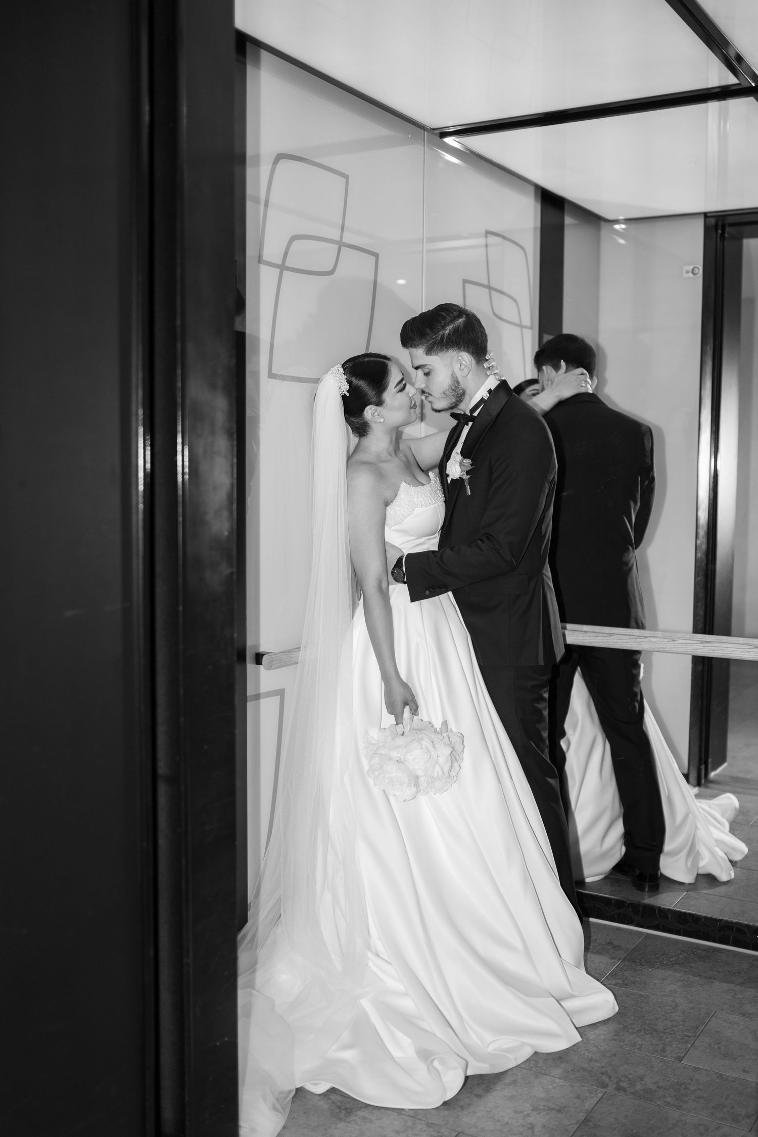 Künstlerische Schwarz-Weiß-Aufnahme eines Brautpaars in modernem Interieur mit Spiegeln – elegante Hochzeitsfotografie von Melér Wedding.