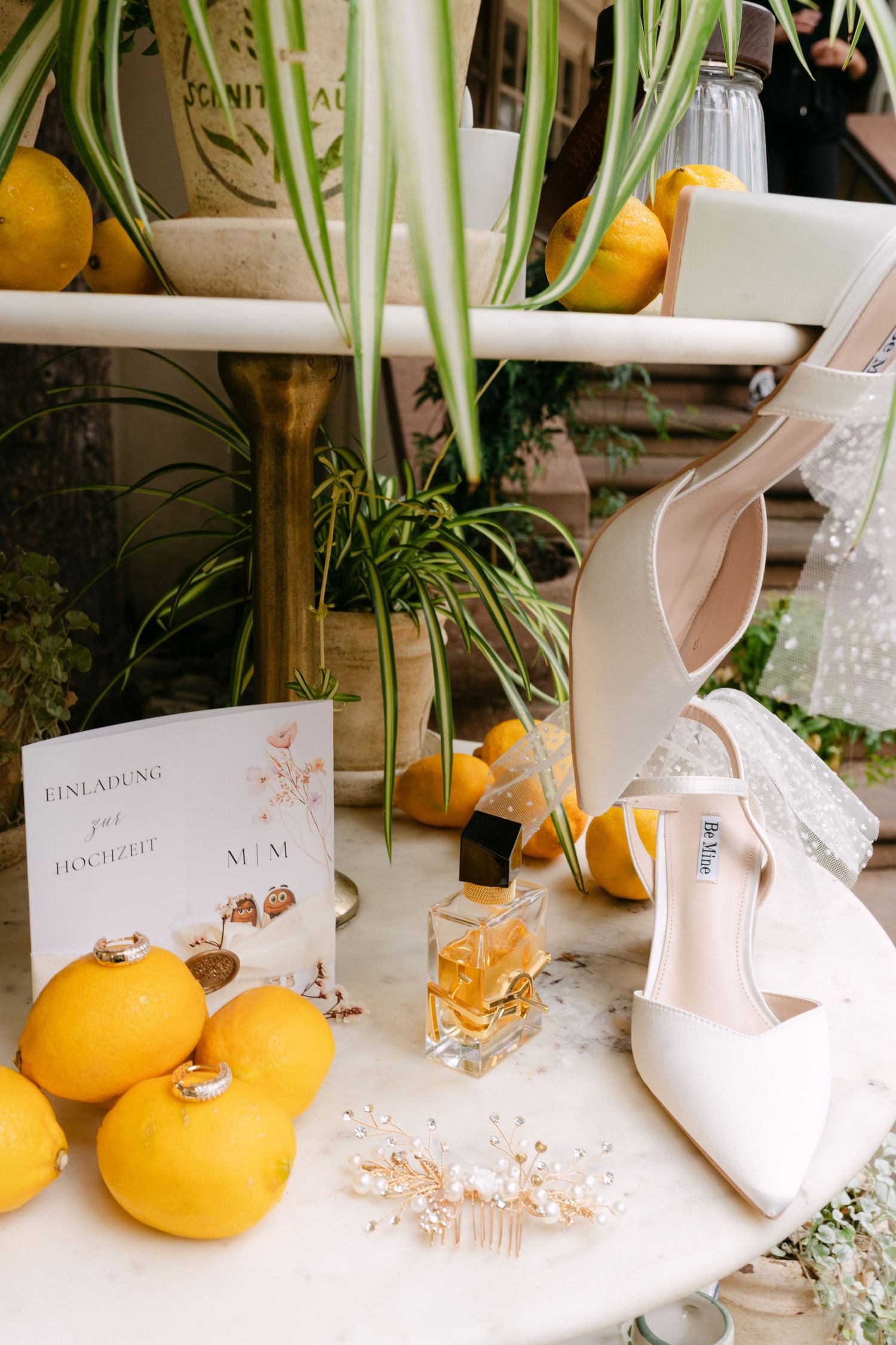 Wedding table decor featuring citrus fruits, place cards, and bridal accessories.