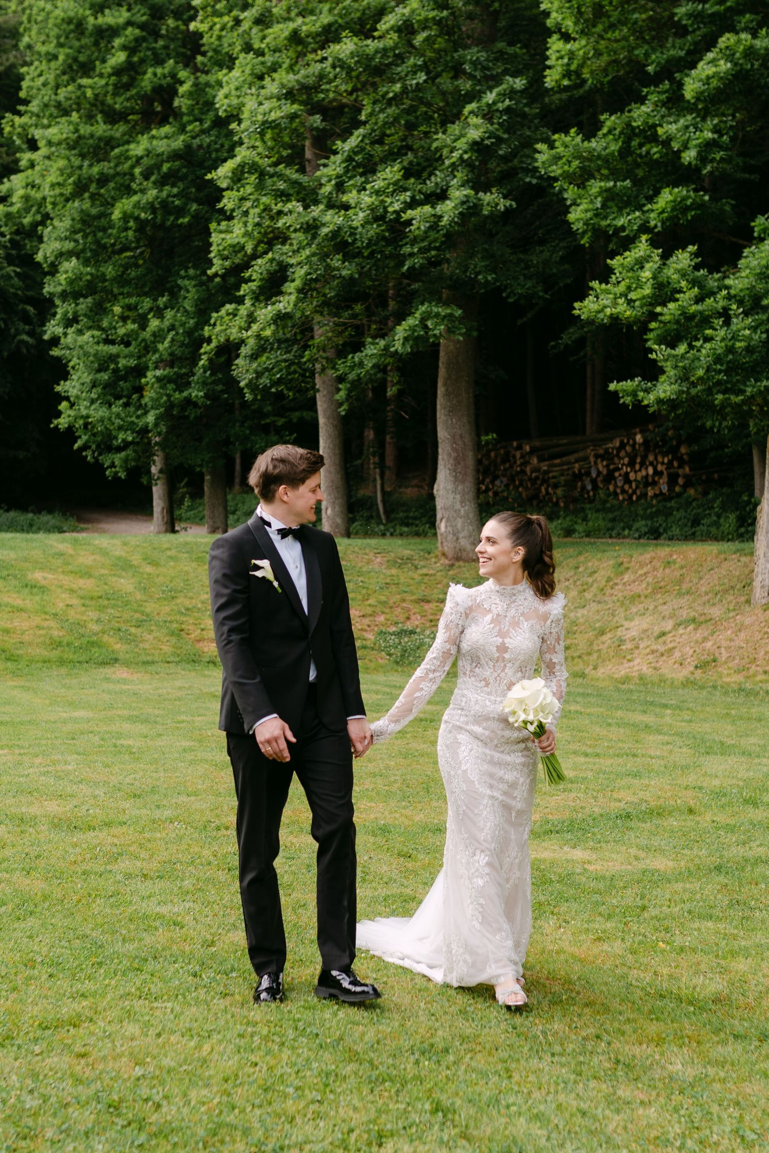 Couple dances playfully on a green lawn during their wedding photoshoot.